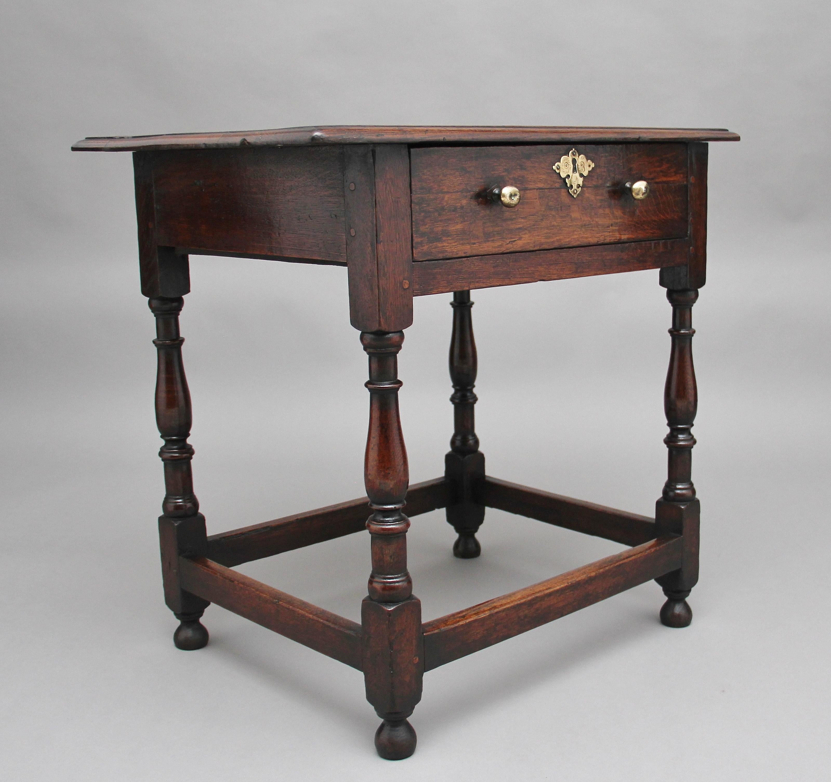 An early 18th century oak side table, the rectangular moulded top above a single frieze drawer with brass knob handles and escutcheon, raised upon ring turned baluster legs on onion shaped feet united by plain cross stretchers, circa 1740.
 
  