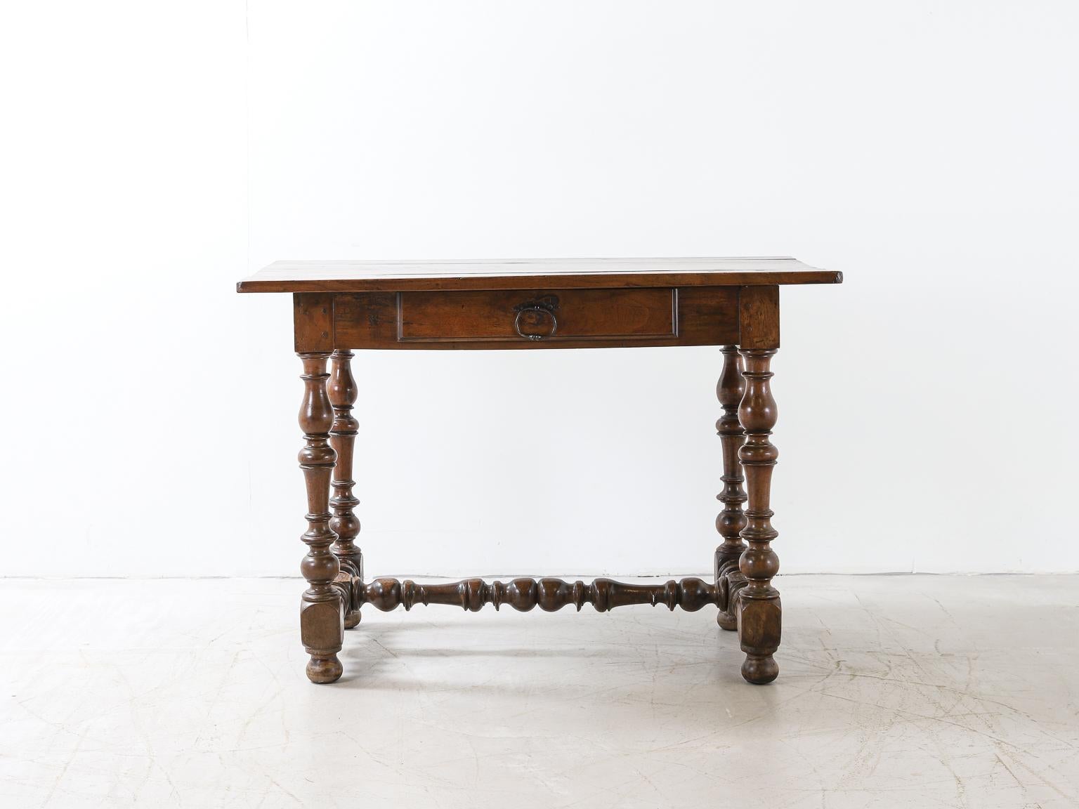 An early 18th century oak table originating in Europe. With beautifully turned legs connected by a stretcher, boarded top and single drawer with original iron pull.
