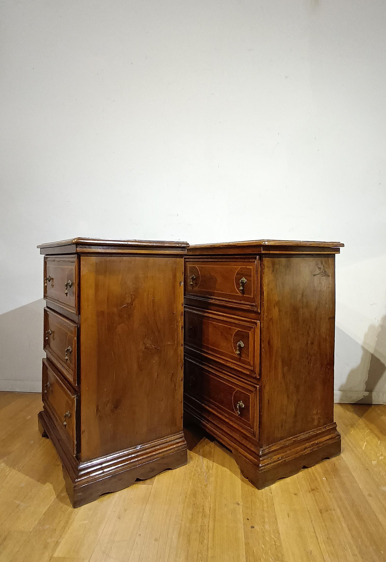 Elegant pair of small chests of drawers in solid walnut, carved and veneered, with lemon wood fillets. The chests of drawers have three ergonomic drawers ideal for storing objects, with fir interiors and which can be opened using lost-wax cast