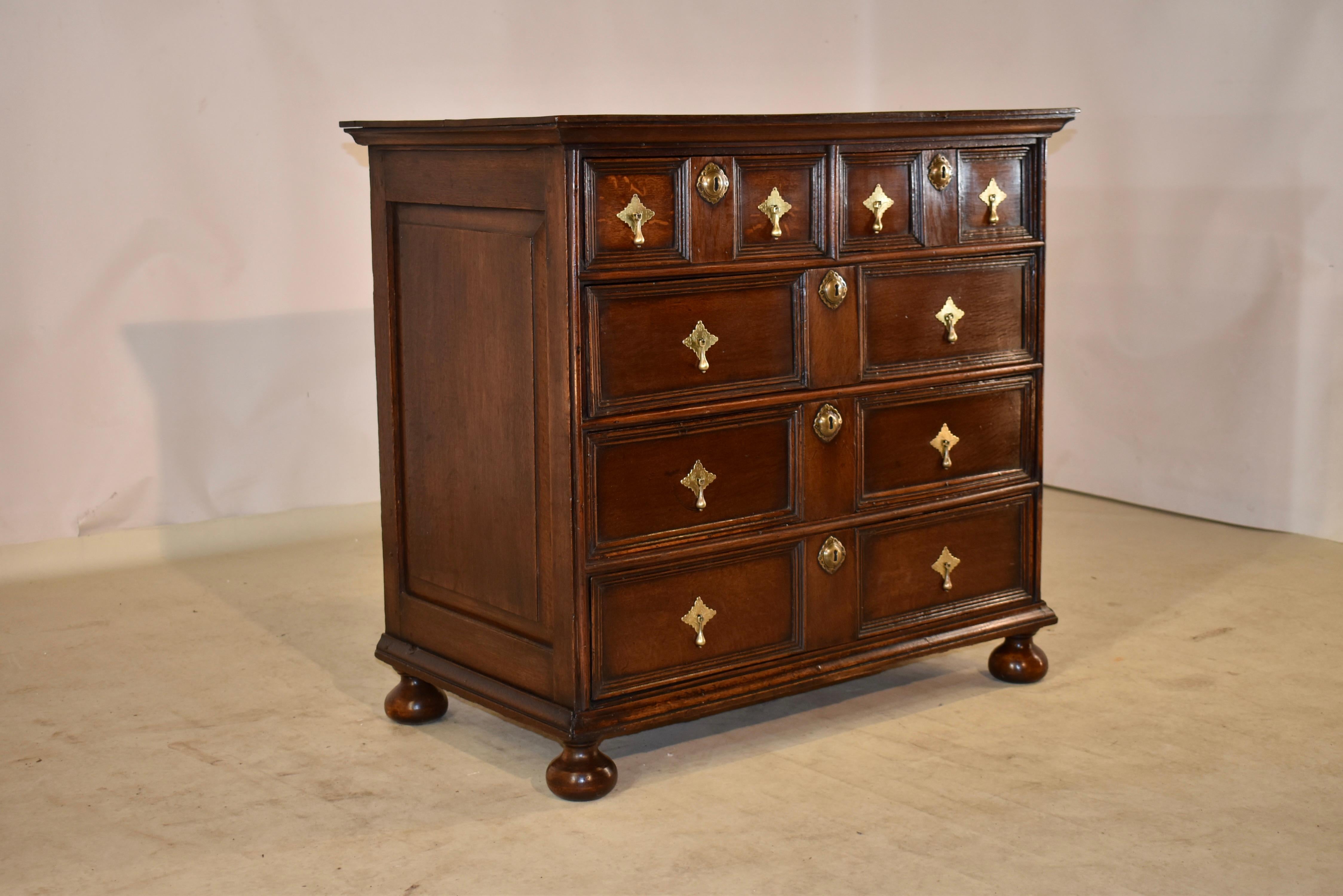 Early 18th century oak paneled chest of drawers from England. The top is made from two boards, following down to hand raised paneled sides, and two drawers over three drawers in the front. All of the drawers have gorgeous molding framing the drawer