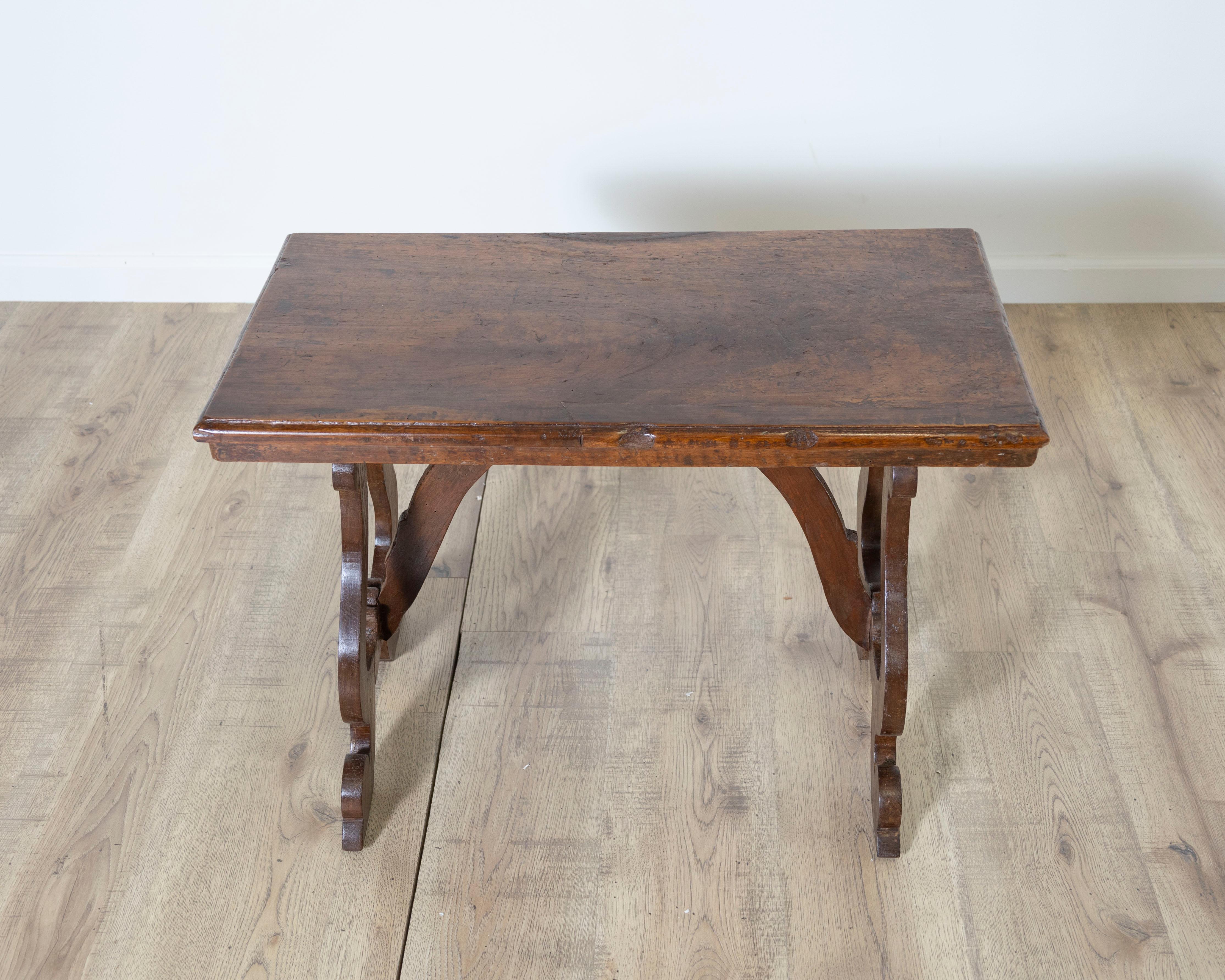 Une élégante et petite table fratino toscane en noyer massif, datant de la première moitié du XVIIIe siècle. Cette table de réfectoire raffinée présente un plateau rectangulaire à la patine joliment vieillie, soutenu par des pieds sculpturaux en