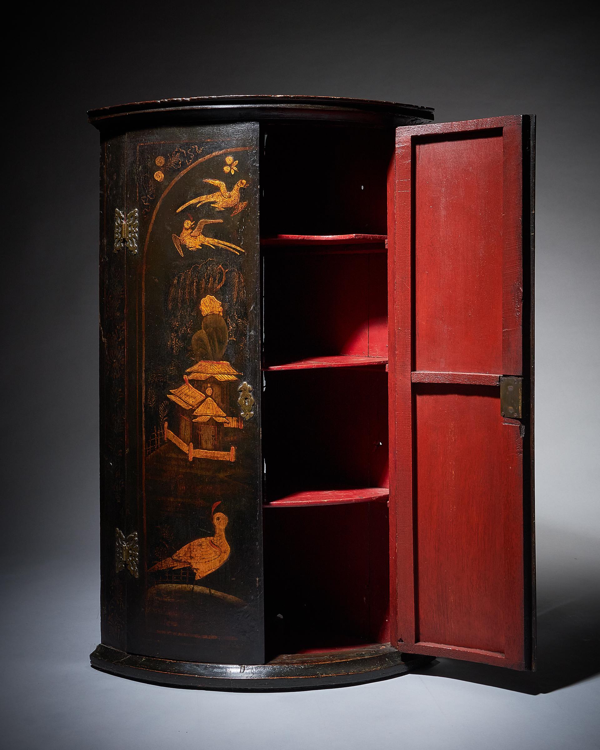 A very atmospheric and original Queen Anne to George I black japanned chinoiserie corner cupboard. England, circa 1720-1740

The exterior is decorated in naive chinoiserie scenes depicting figures, birds, foliage, insects, dwellings and the sun.