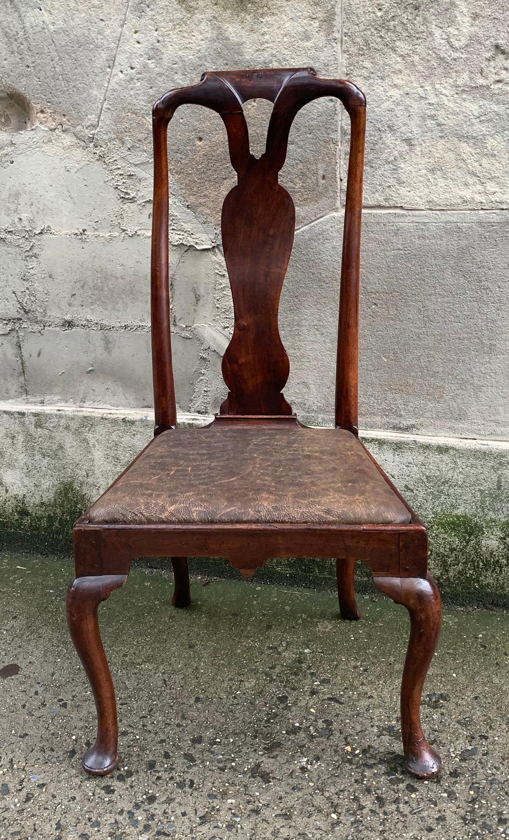 Beautiful walnut Queen Anne side chair with a slender vase splat with a molded and pierced crest rail. Dramatic cabriole legs on front and rear of the chair terminating in pad feet. The drop seat is covered in an olive green calf hide leather, circa