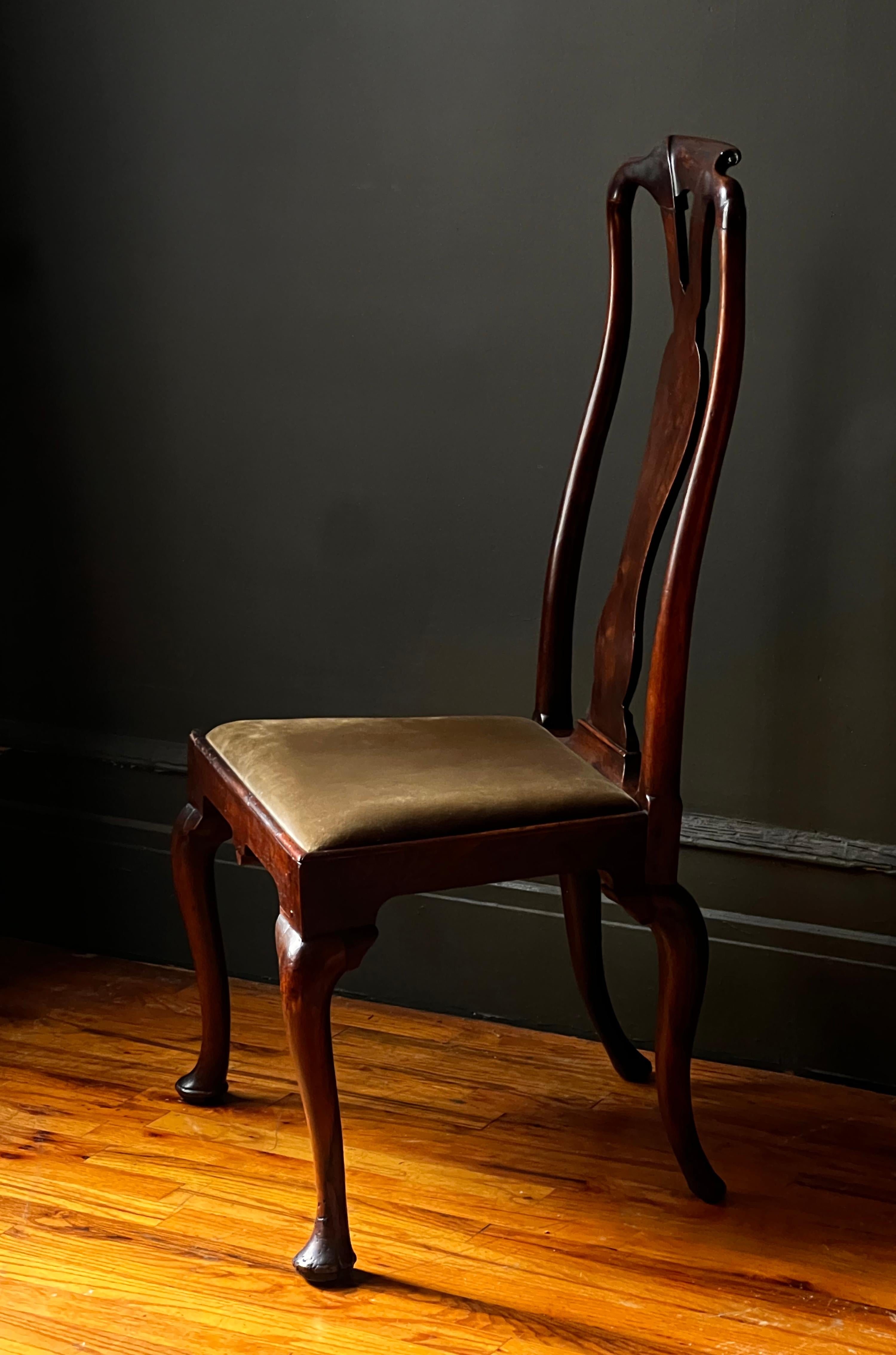 A beautiful walnut Queen Anne side chair with a slender vase splat with a molded and pierced crest rail. Dramatic cabriole legs on front and rear of the chair terminating in pad feet. The drop seat is covered in a gold green olive velvet. Irish or