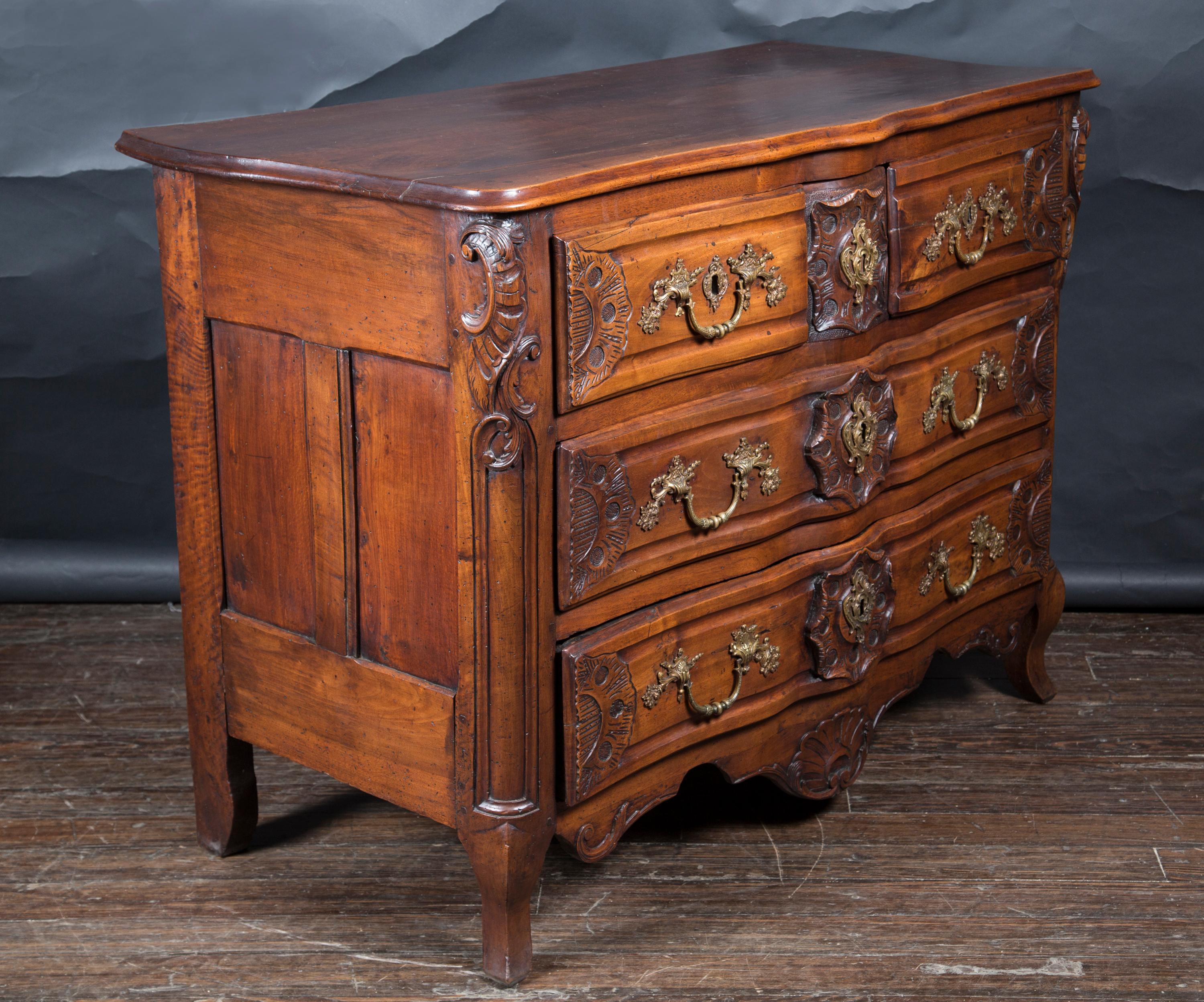 This rare and unusual Lyonnaise commode dates back to the 18th century and is made of beautifully carved walnut. The piece features five drawers with the original bronze handles and escutcheons. The top row features a secret center drawer that opens