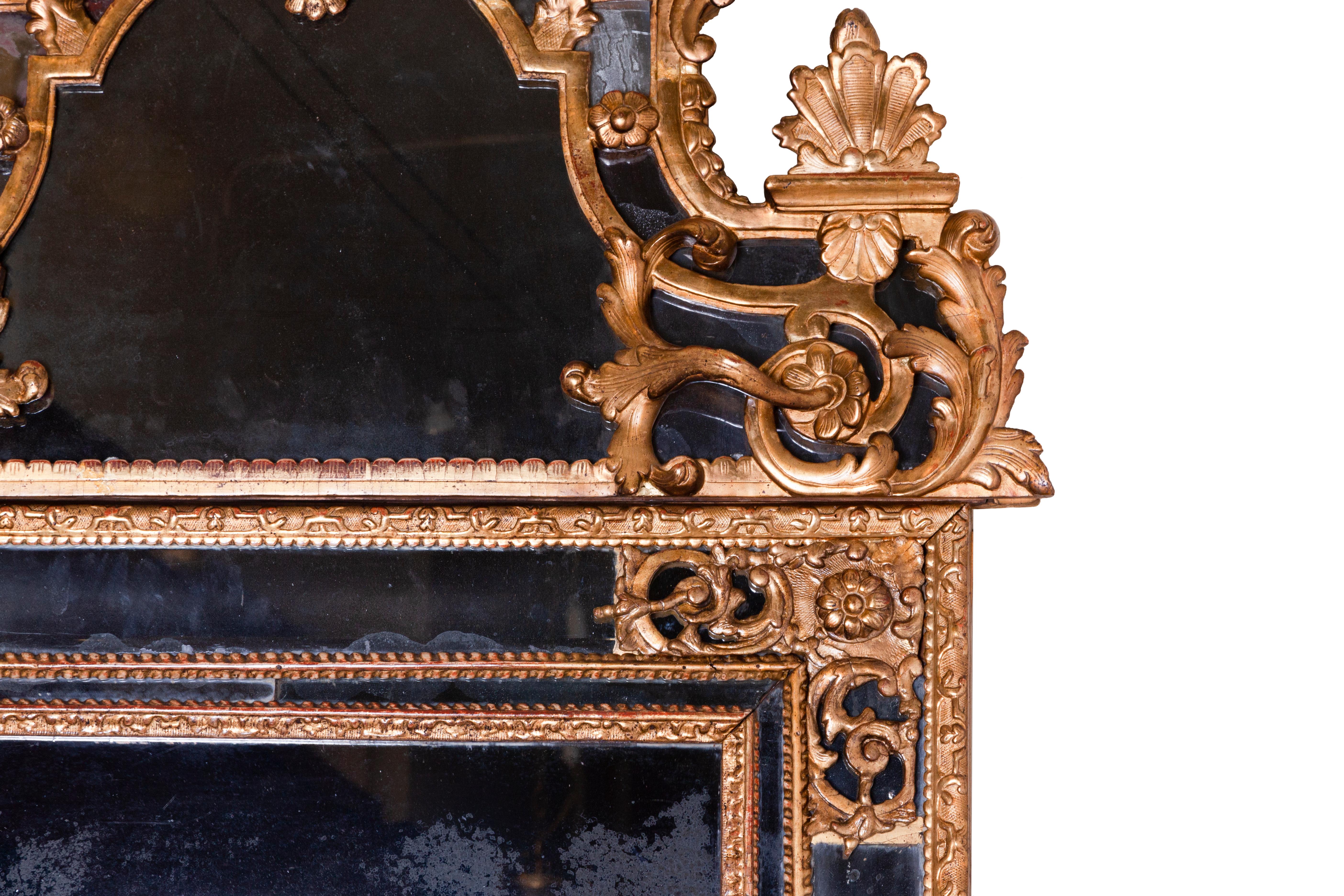 Regency giltwood mirror from the early 18th century.
It has a central rectangular mirror plate surrounded by four marginal plates set between carved and gilded pinewood framing sections.