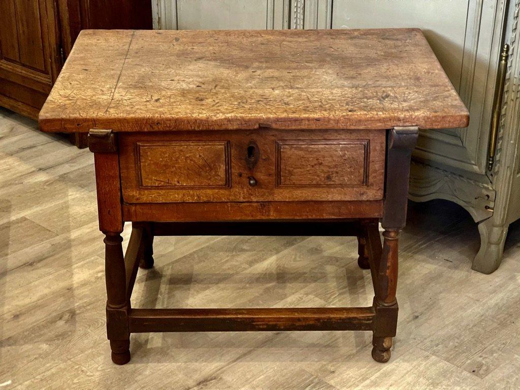 Early 18th Century single drawer Spanish walnut tavern table. The stretcher base with turned legs supporting carved paneled aprons and a drawer front with a cleated single-board top. 25.5” h. x 34” w. x23.5” d.