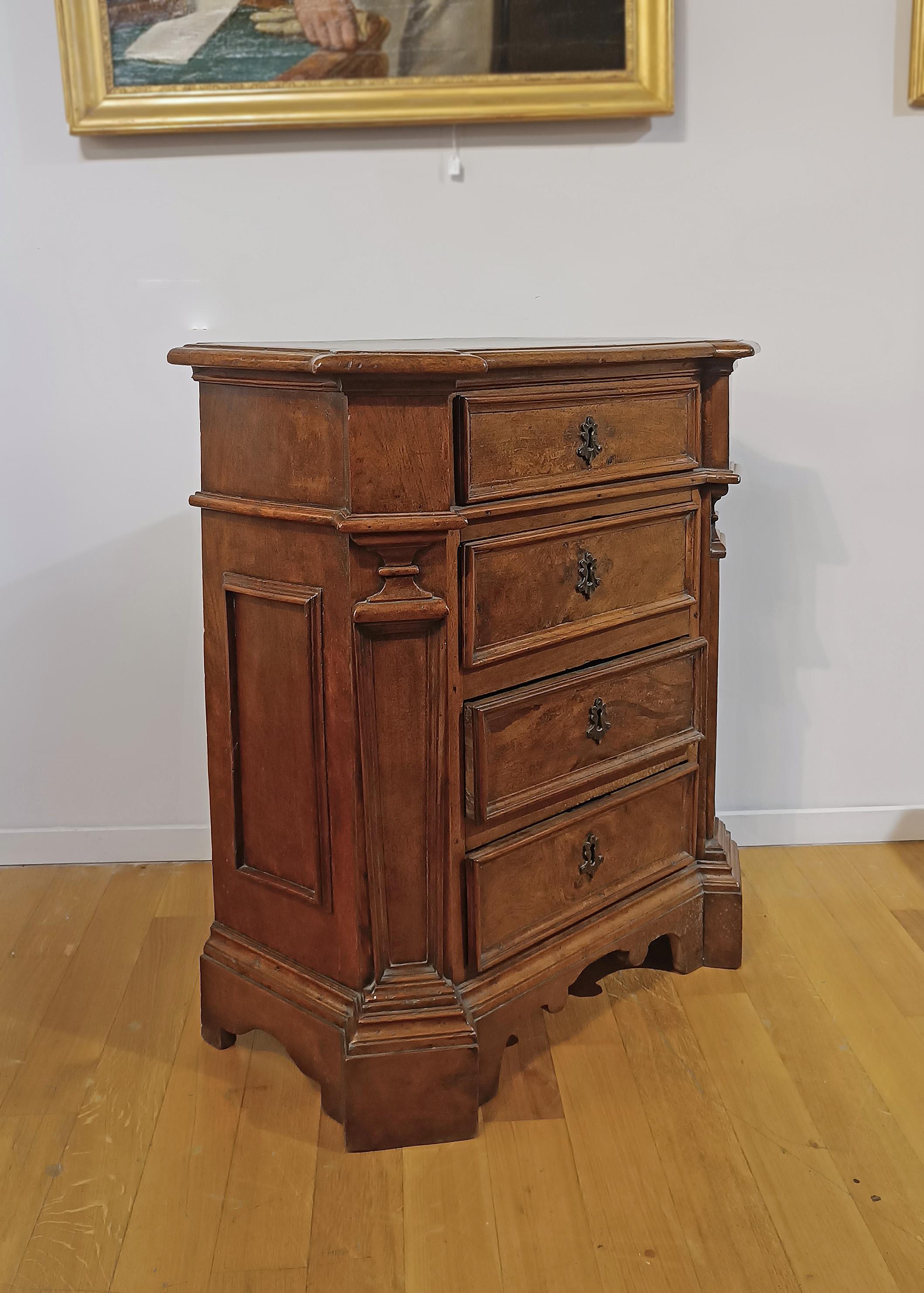 Beautiful chest of drawers in solid walnut, of small dimensions. The structure has rounded corners, as does the top, enriched by geometric tiles on the sides and corner columns. The piece of furniture is embellished with bracket feet and is equipped