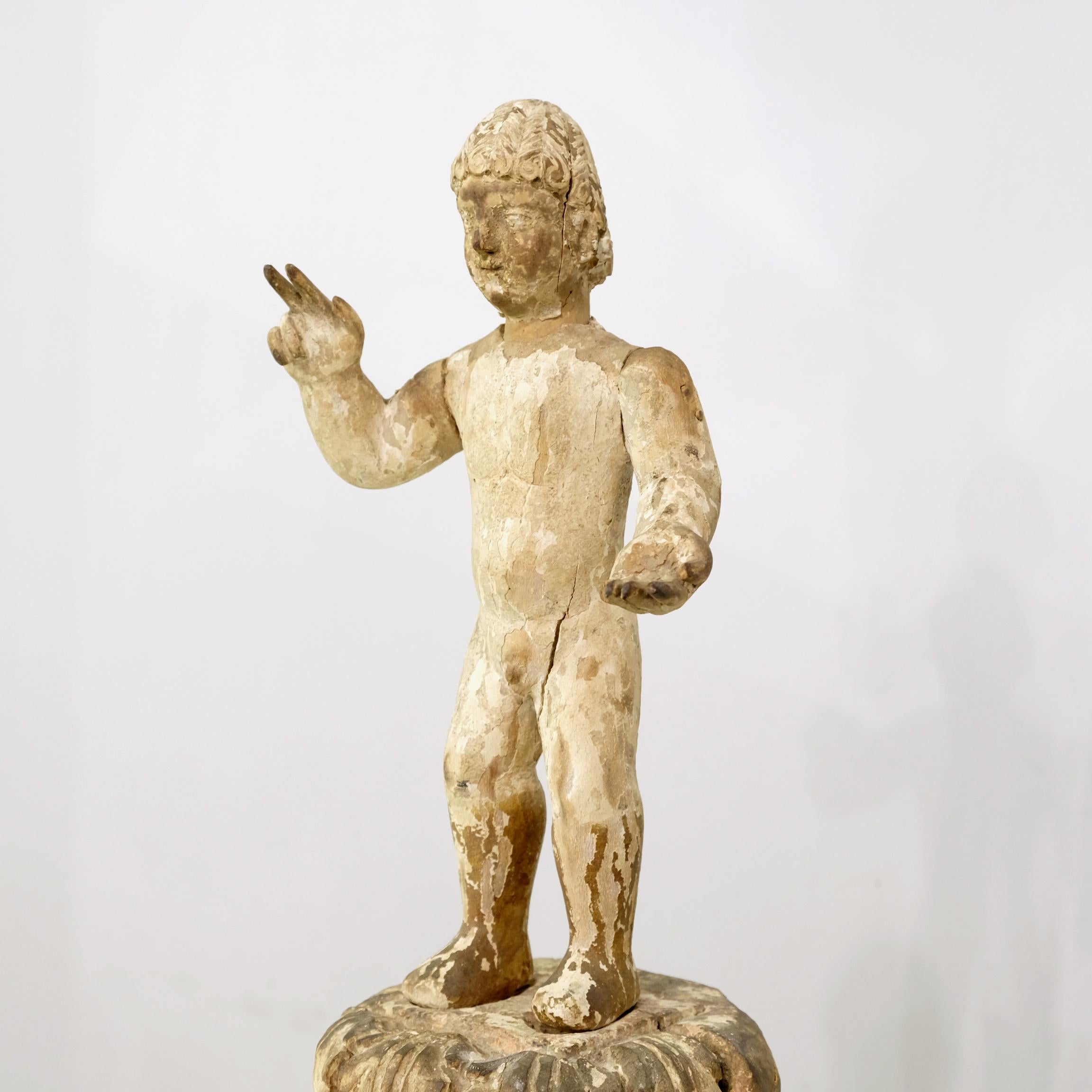 Hispanic Santo Niño or Christ Child dating from the late 17th to early 18th Century, hand-carved in pine and exhibiting its characterful original gesso with traces of original polychrome paint. Holding his right hand to offer a blessing, his left