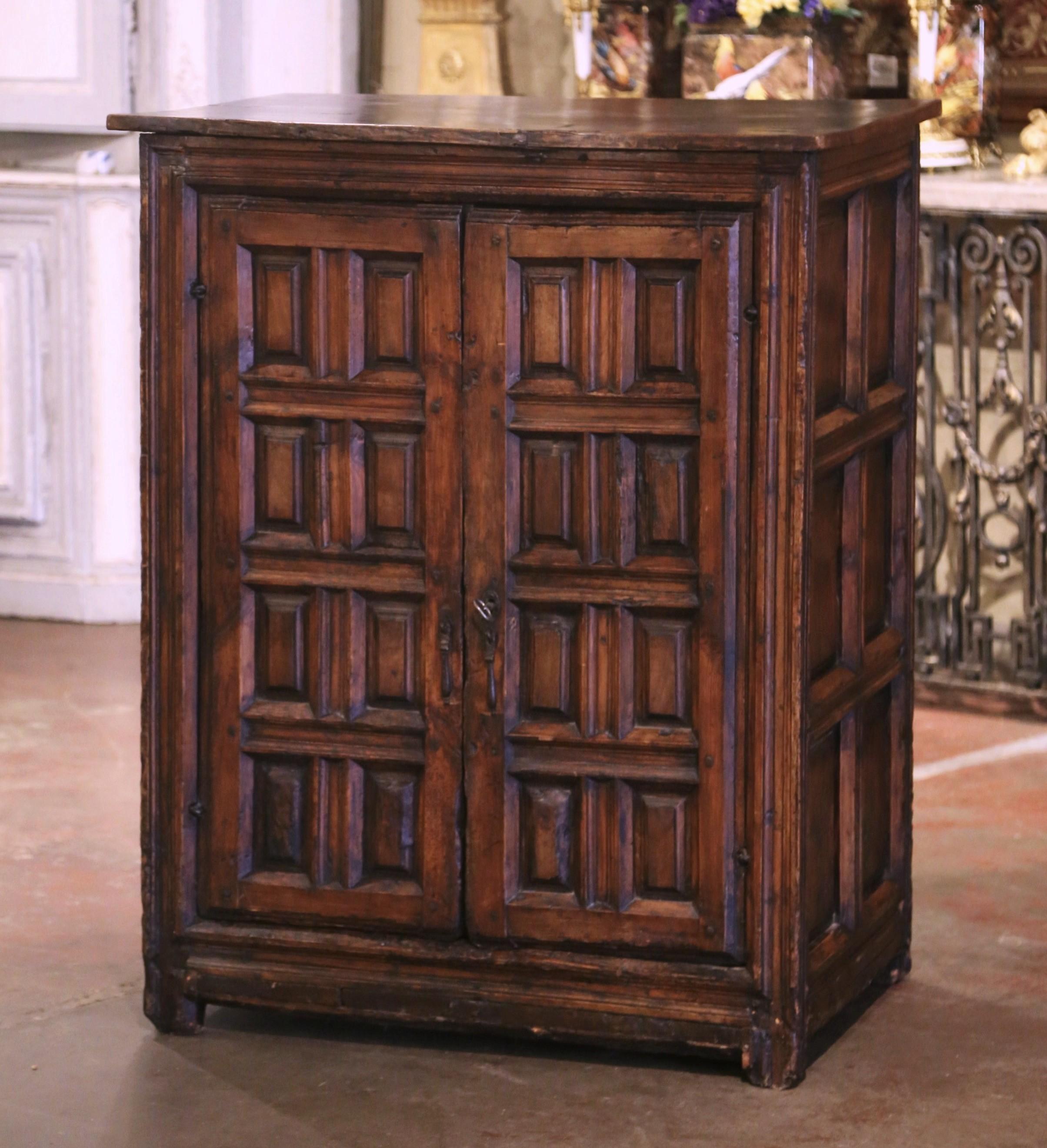 Intagliato a mano nel nord della Spagna intorno al 1720, questo raffinato mobile antico mostra una maestria artigianale e un'eleganza senza tempo. Realizzato in noce massiccio, presenta una patina ricca e invecchiata che ne esalta il carattere. Le
