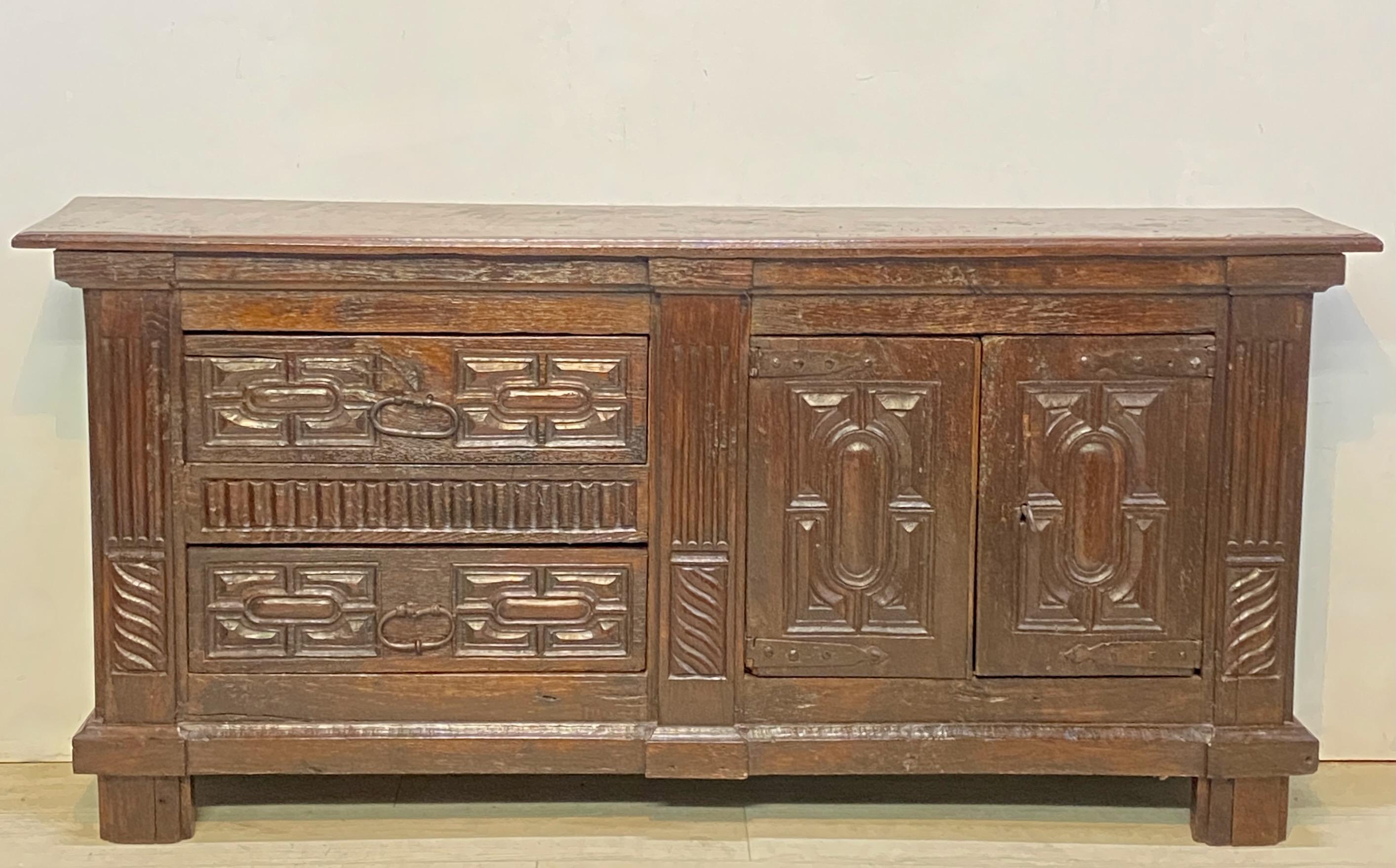 Carved oak low side cabinet or credenza with original hand forged wrought iron hardware and original lock with working key.
Very old if not original finish.
Possibly reduced in depth some time ago.
Spain, late 17th century - early 18th century.