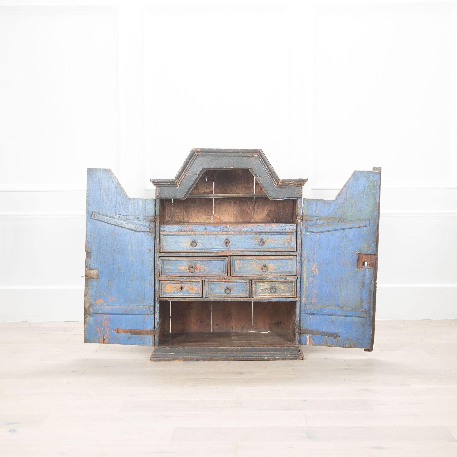 Early 18th Century cupboard from Northern Sweden in original paint.
The pair of doors open to reveal an interior fitted with drawers and shelves.
The exterior is in a traditional dark grey paint with fine decorative escutcheons.
The interior is