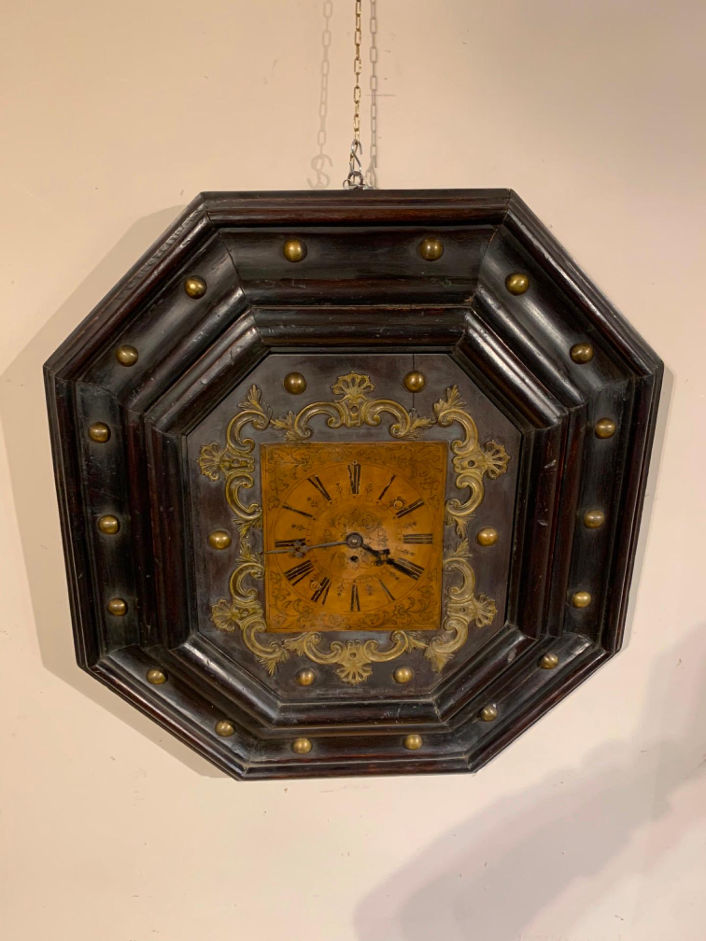Beautiful octagonal shaped wall clock made of solid walnut with patinated bronze finishes and semi-cylindrical head nails.
Rectangular chiseled dial, daily winding without alarm and suspended pendulum.
Tuscan manufacture from the first half of the