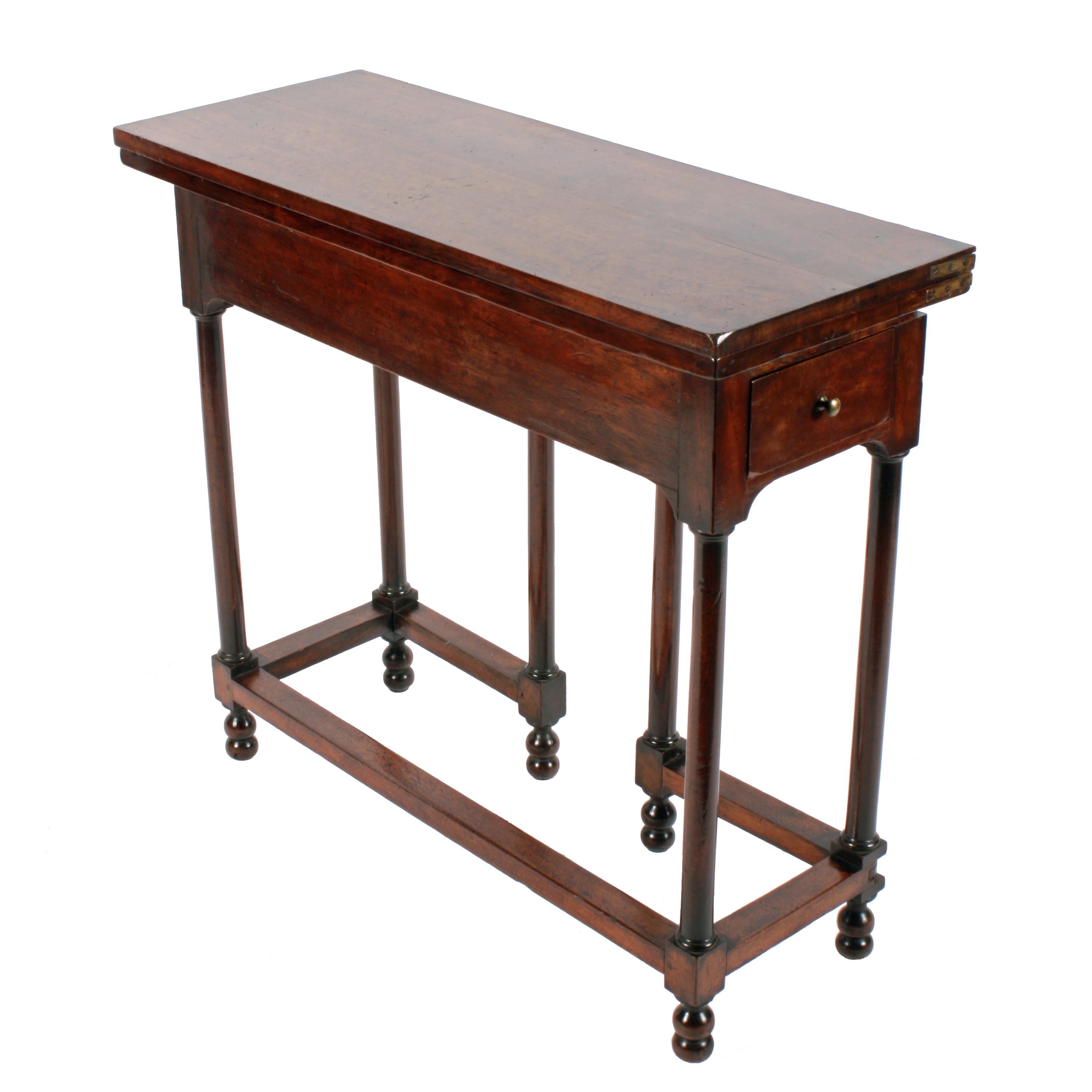 Early 18th century walnut card table.


A rare early 18th century walnut turn over top card table.

The table stands on six turned legs with cross stretchers with gated legs at the back to support the leaf when open.

Each end has a narrow