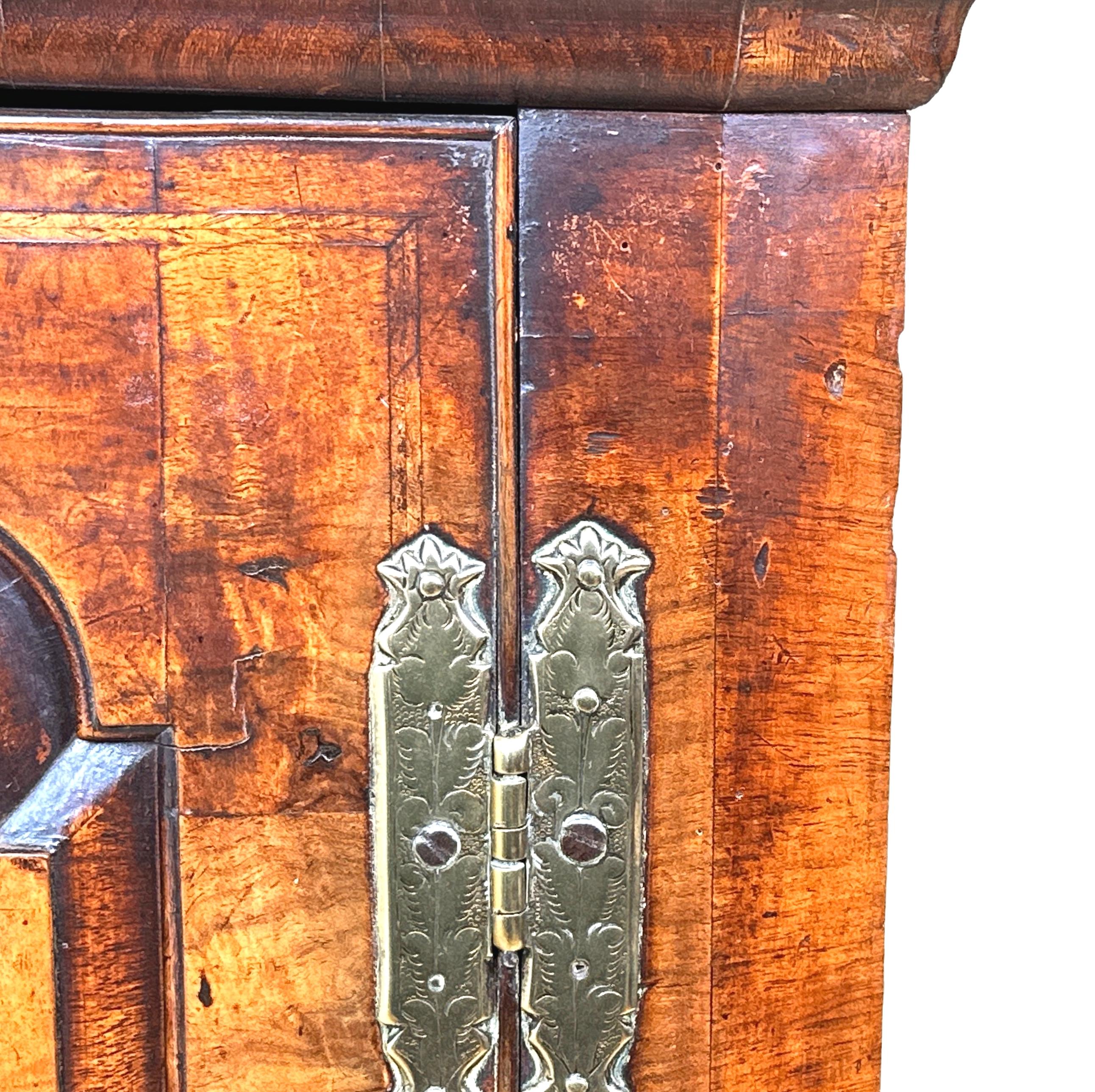 An Extremely Attractive And Very Good Quality Early 18th Century, Queen Anne Period, Walnut Wall Hanging Corner Cupboard, Of Exceptional Untouched Colour And Patina, Having Elegant Fielded Panel Door, With Original Brasswear Enclosing Shaped