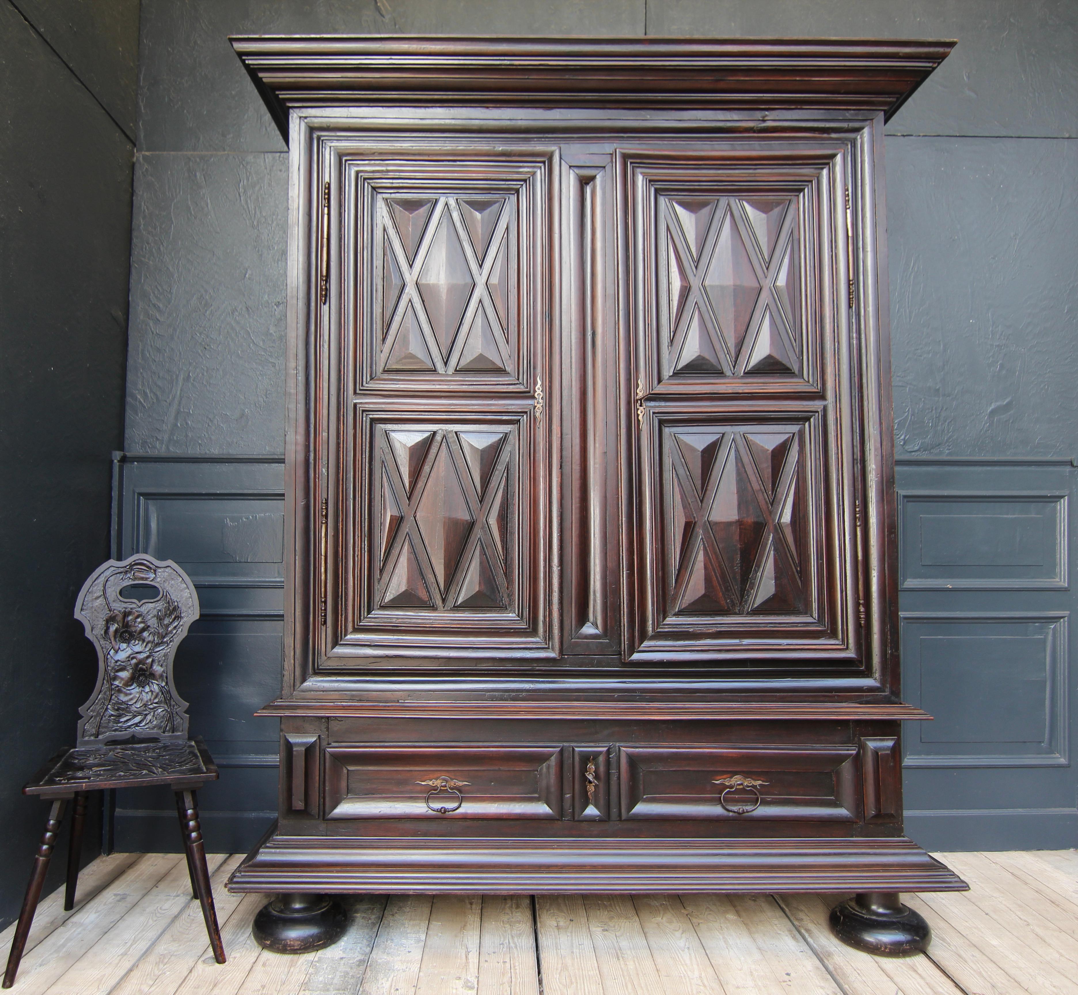 Exceptional large French Louis XII armoire from the early 18th century made of walnut and oak. 
2 doors with external hinges and a large drawer in the base. So-called diamond panels in the doors, as well as laterally cassetted. The wood has