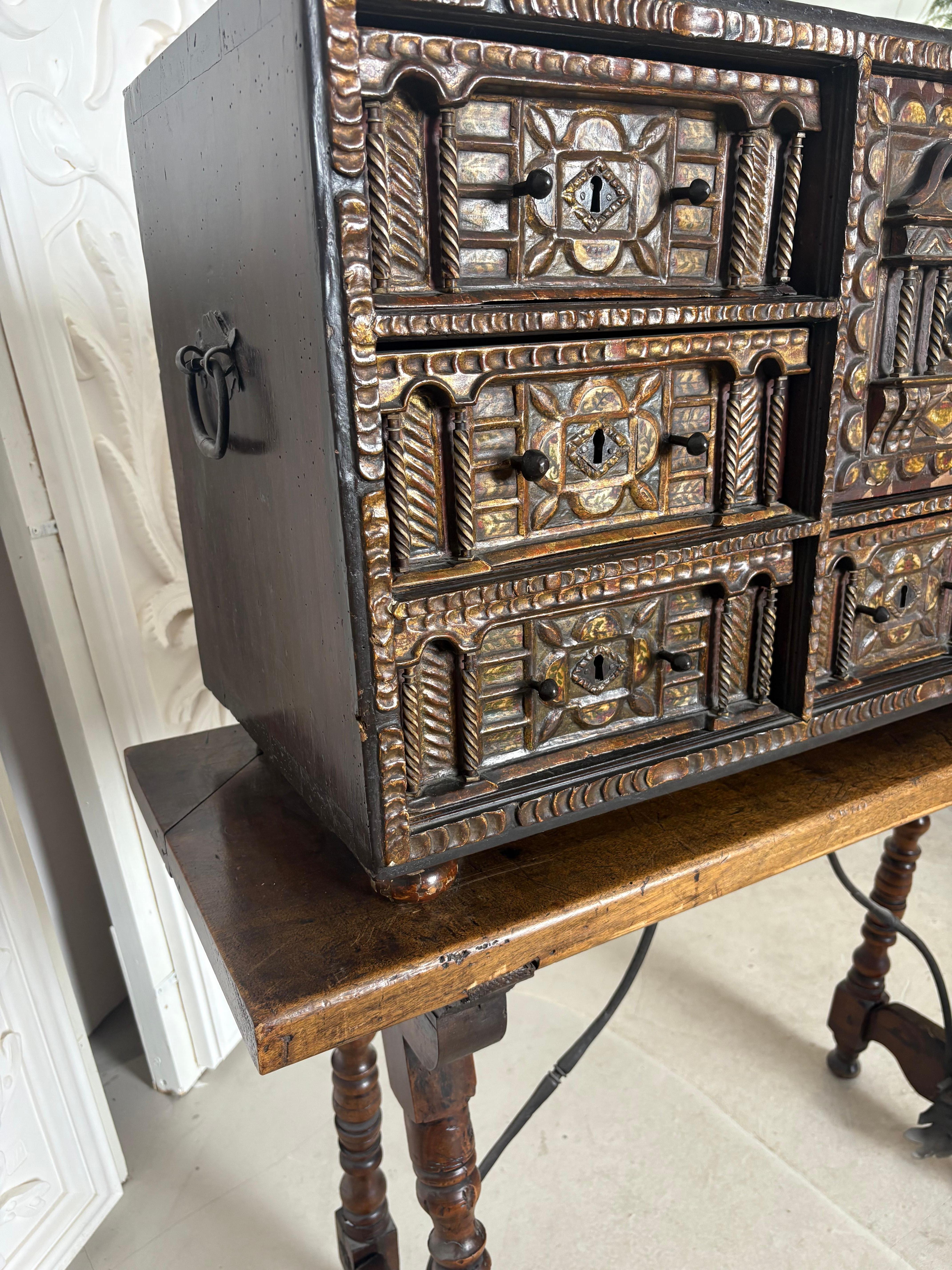 An early Eighteenth Century Spanish walnut Vargueno with original polychrome decoration and bone inlay. Highly decorated walnut cabinet resting on bun feet raised on a walnut stand of typical form with turned end supports united by a shapely iron