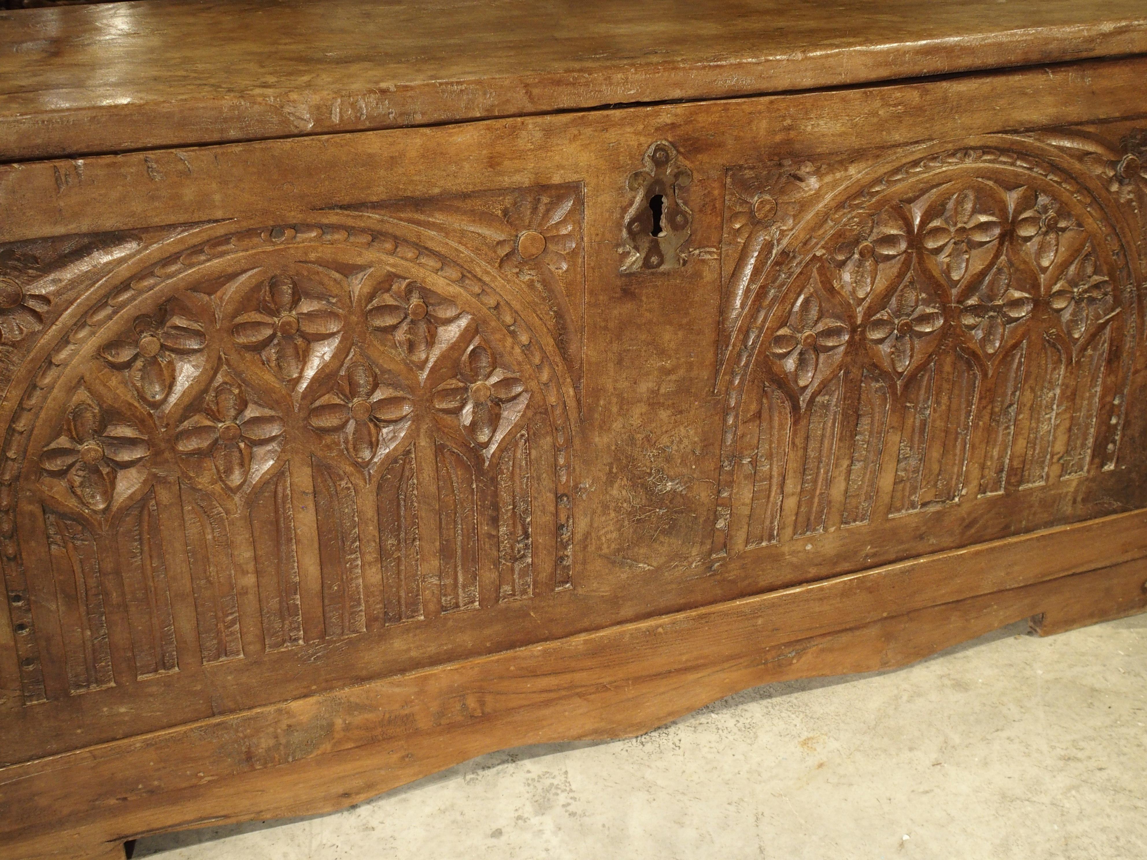 This antique French Gothic style trunk is from the early 1700s. It has been left in its original condition, with just a dusting and a light French wax. The only ornamentation is on the front with its two domed semicircles having quatrefoils, pointed