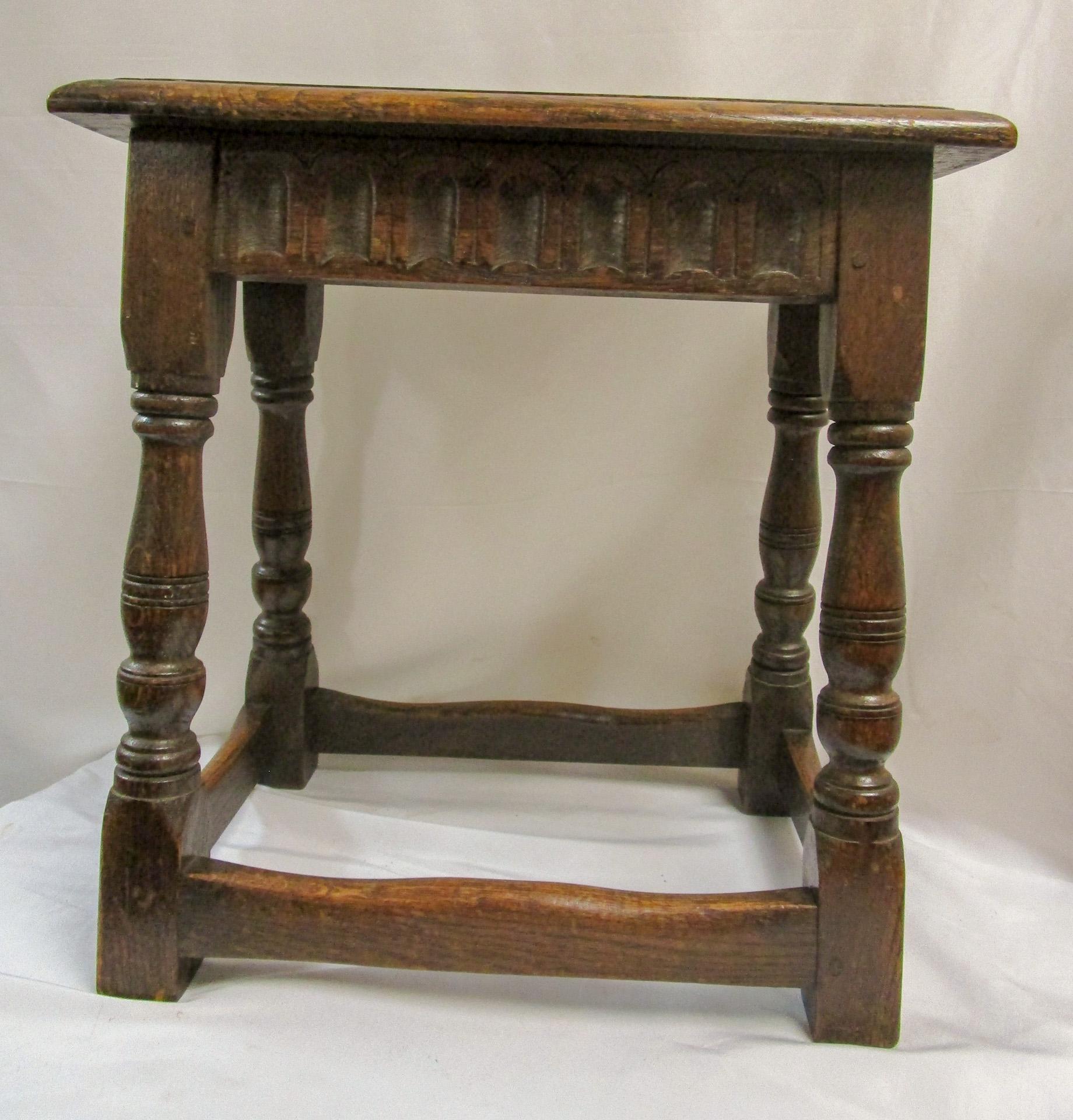 Not many pieces of this age have stood the test of time. This very early English joint stool is handcrafted of oak, note the rough burls on the top of the piece.  It is of pegged construction and features block and turned legs. Primitive but