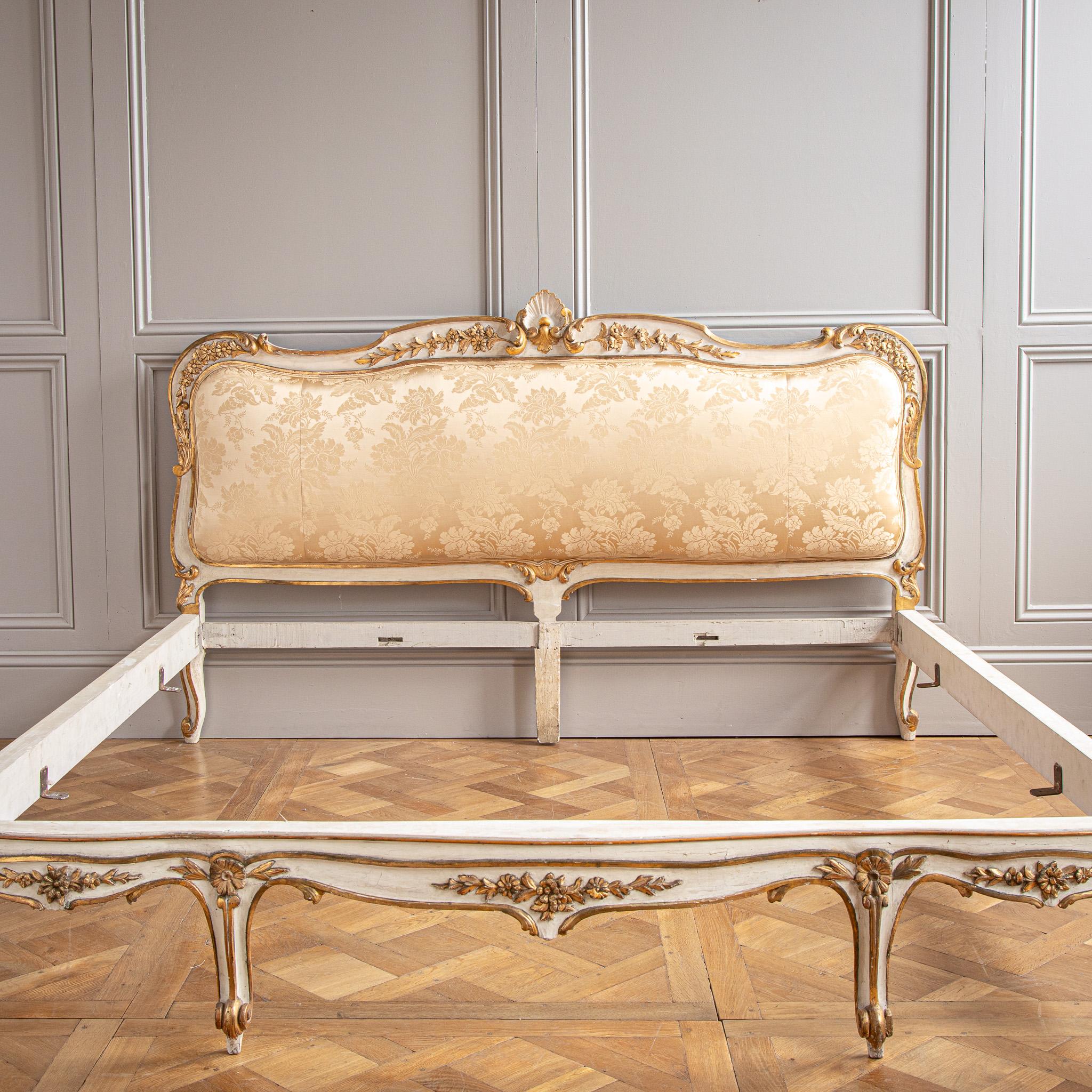 This turn-of-the -century antique bed which was made to take a large mattress size, is from Florence, Italy and is made in the Rococo style. The bed frame features lyrical curves accentuated by a beveled line work that enhances its flowing design.