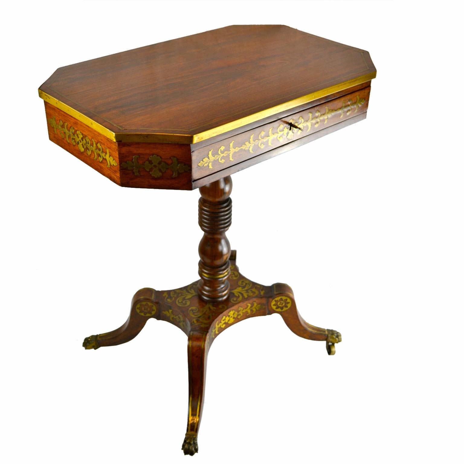 An English Regency rosewood table of the highest quality with the trademark inset brass decoration. The octagonal top is framed in brass over a richly decorated apron with a drawer to one side; the top is supported on a turned column attached to a