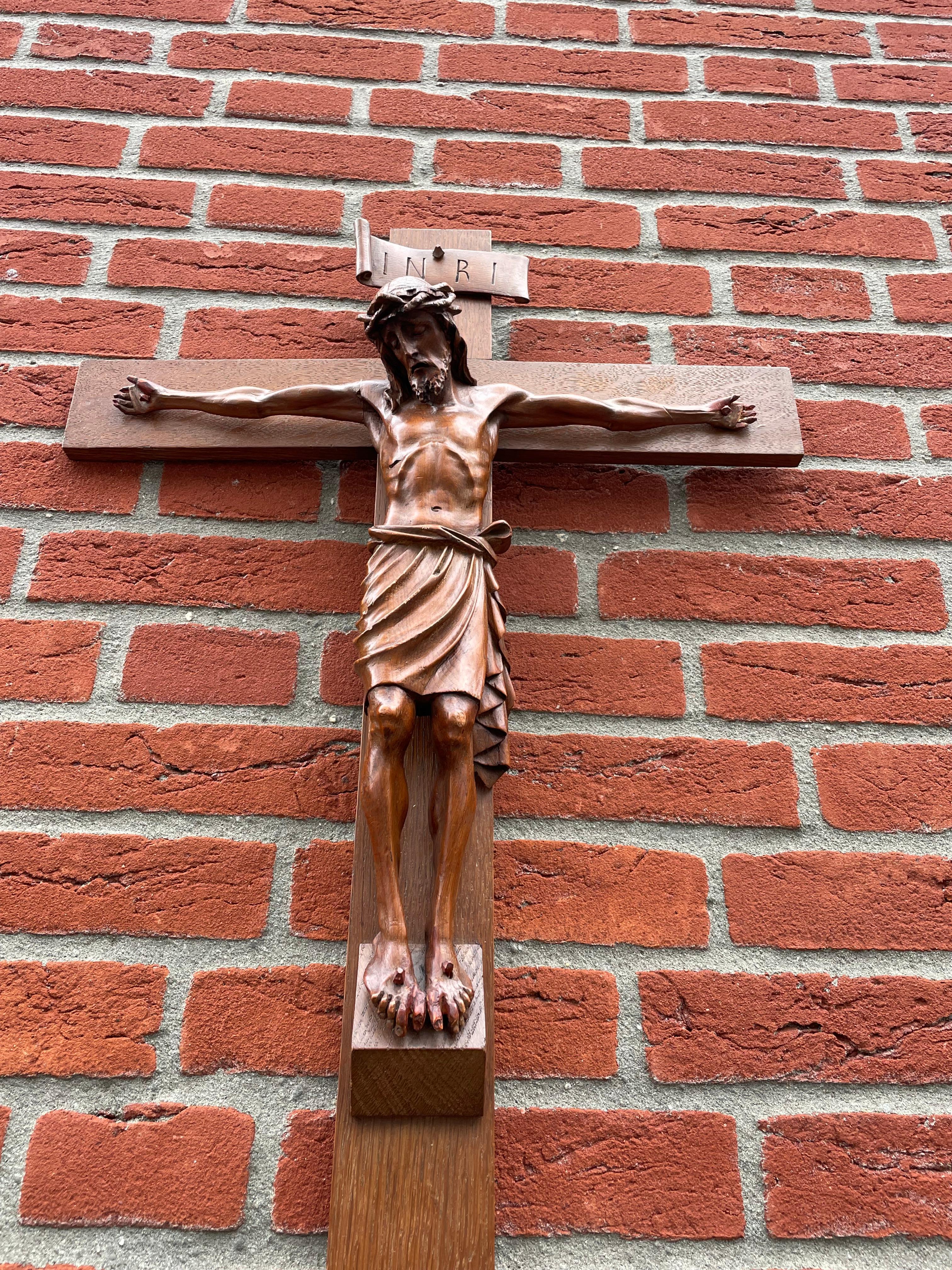 Großes Kruzifix mit einem feiner geschnitzten Christuskorpus.

Wenn wir Christus so betrachten und an die grausame Art und Weise denken, in der er sein irdisches Leben verlor, ist das Kruzifix (aus unserer Sicht) ein Symbol dafür, wozu es führen