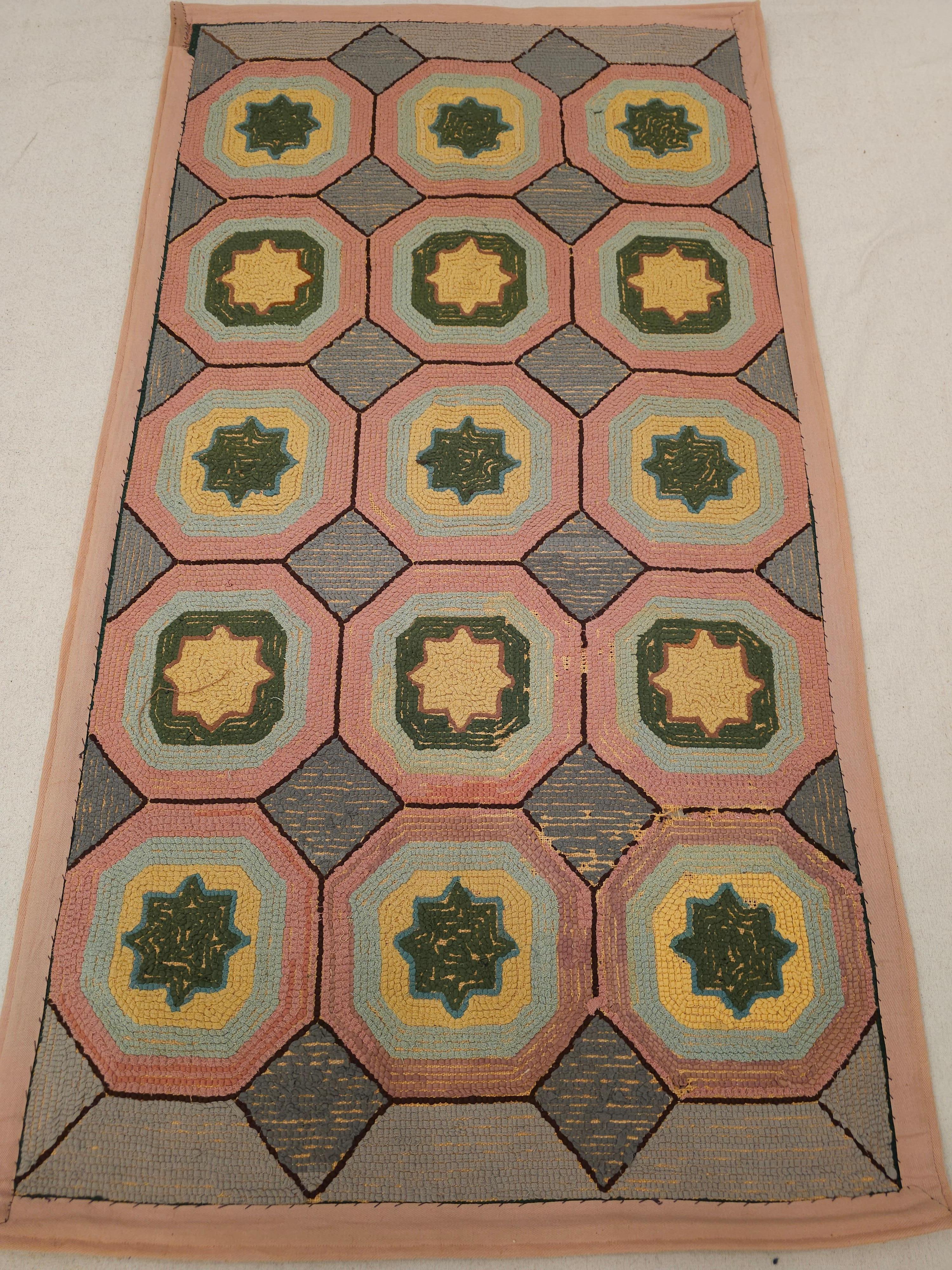 Discover the charm of American folk art with this exquisite Early 1900s Hand-Hooked Rug. Crafted with remarkable artistry, this vintage piece showcases a captivating geometric pattern rendered in a soft, inviting palette of gray, blue, pink, and