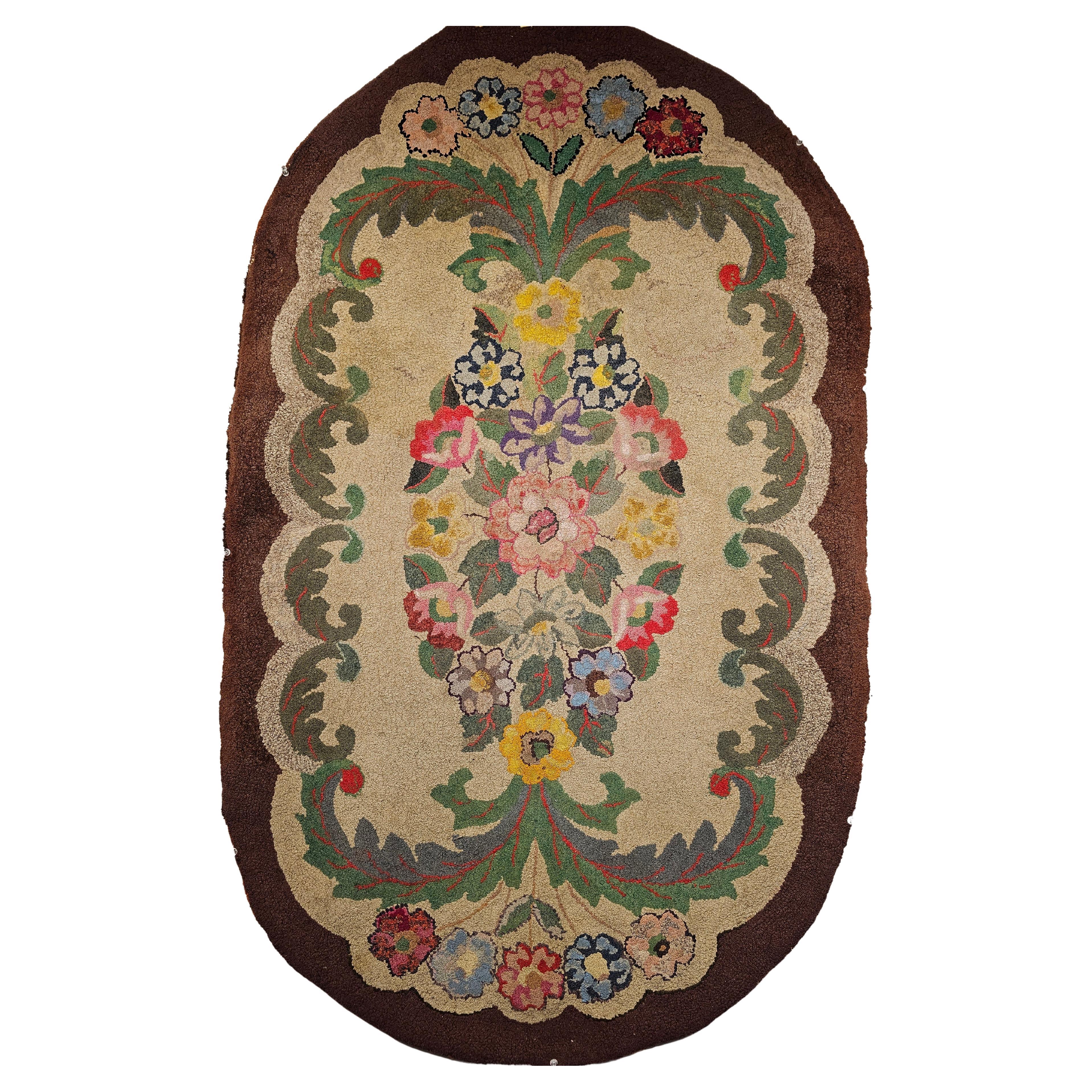 Vintage American hand hooked rug was handcrafted in the early 1900s in the New England Area of the United States.  It has a floral pattern with flowers in brilliant vintage colors including ivory, green, blue, and red.  The Antique Hooked Rugs are a
