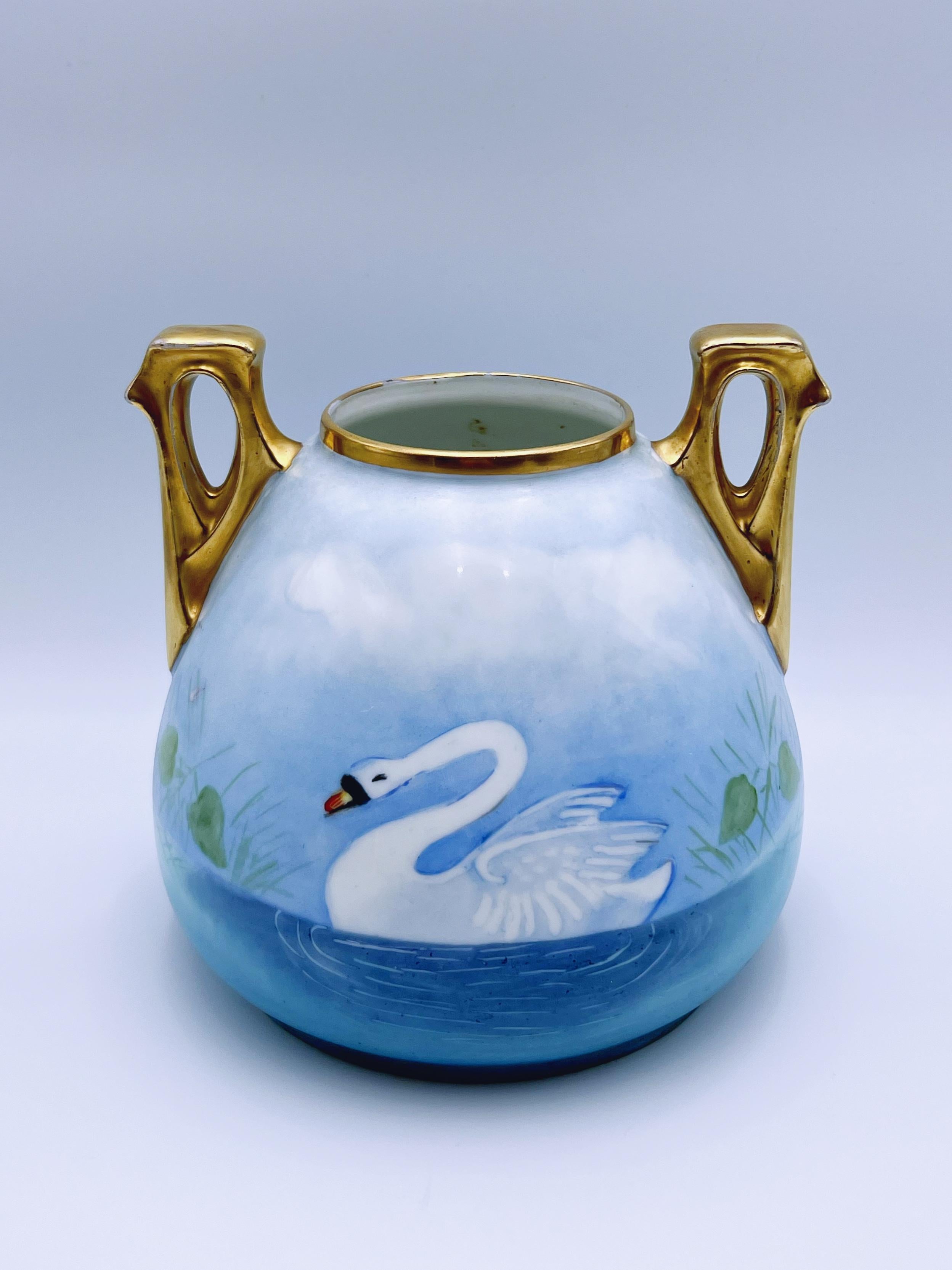 Un vaso-urna in porcellana antica davvero unico nel suo genere, con un bellissimo manico dorato a 24 carati. 

Con il marchio SILESIA (in uso dal 1900 al 1920), questo pezzo è stato prodotto dalla rinomata Porzellanfabrik Hermann Ohme, attiva dal