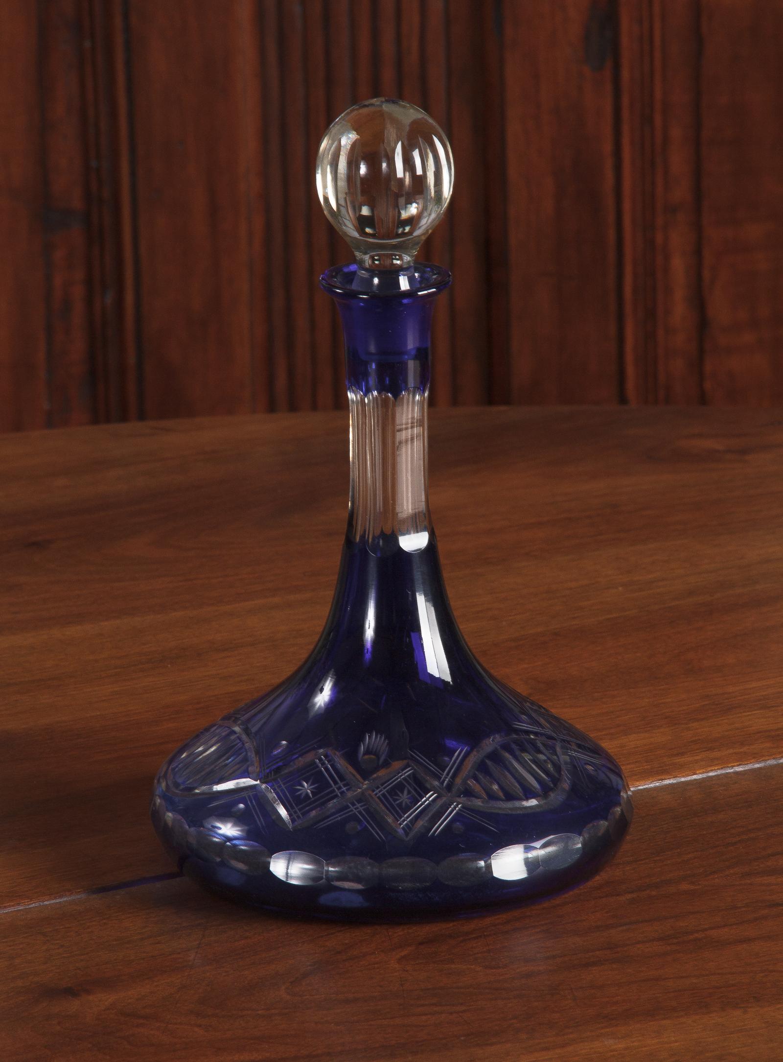 A dazzling cobalt blue Bohemian glass decanter with etched geometrical motifs, Czech Republic, circa 1900. Dramatically shaped with a low, wide belly that slopes up into a long, elegant neck, completed by a round glass stopper. The cobalt blue base