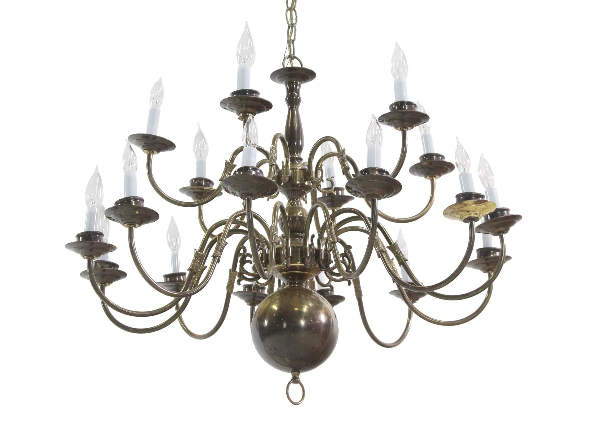 This two tiered Williamsburg style chandelier has 18 lights with scrolled arms and a natural patina. This light has been rewired. This can be seen at our 400 Gilligan St location in Scranton, PA.

