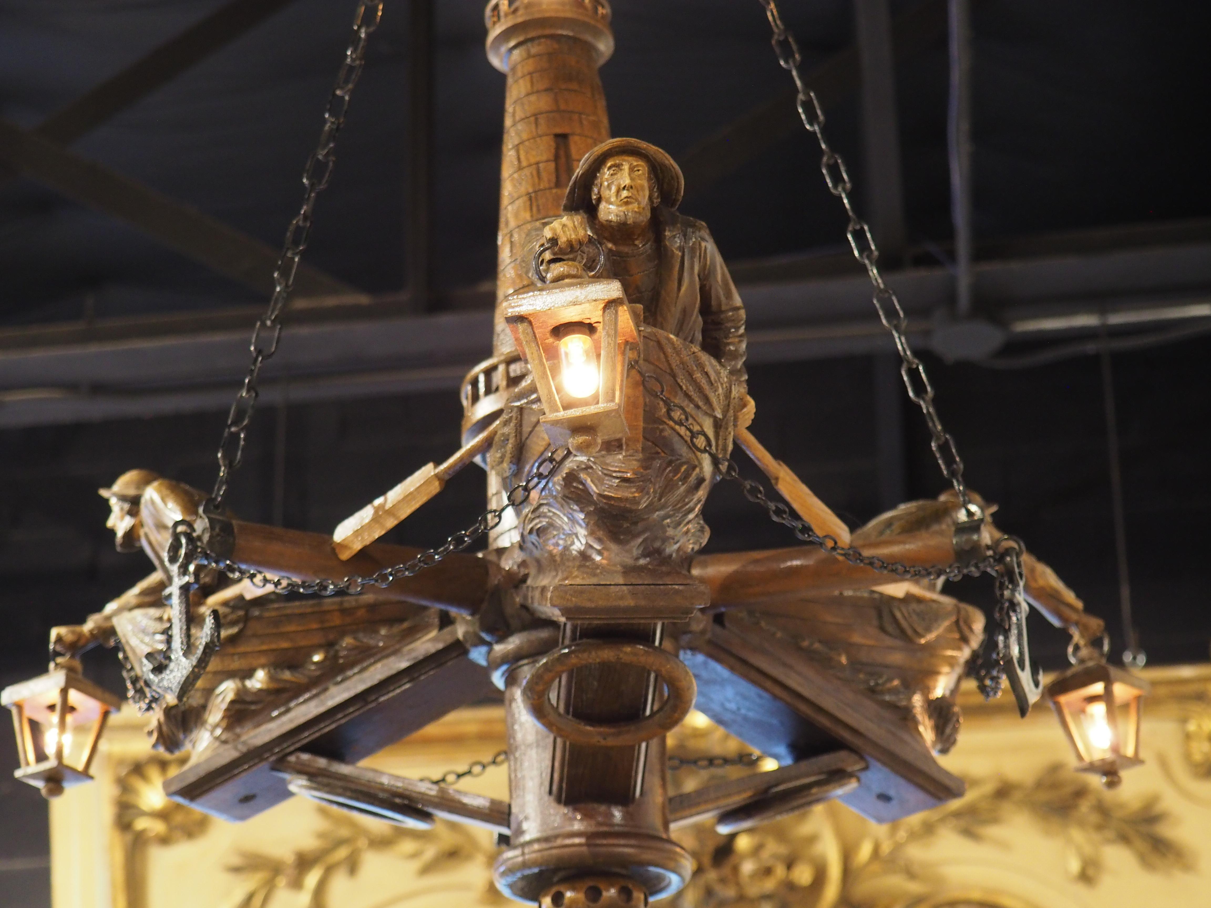 Based on the 19th-century folklore of the lost fisherman of St. Malo, France, this highly carved wooden chandelier also incorporates maritime legends with inscribed boats and life preservers. Hand-carved in the early 1900s in Brittany (Saint-Malo is