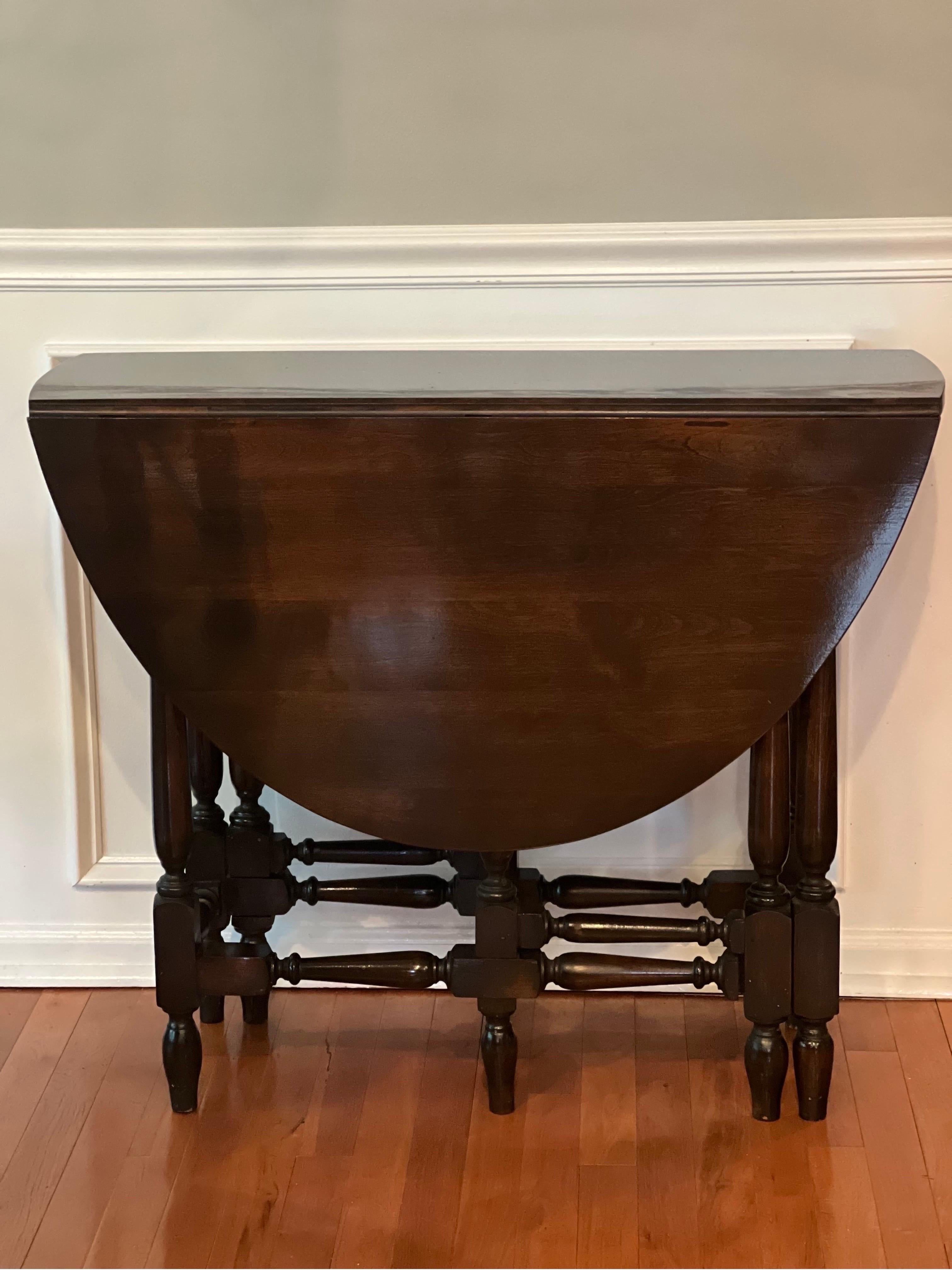 Beautiful early 1900's William and Mary style dark walnut gate leg, drop-leaf table. This oval top table features two drop leaves and baluster legs. When leaves are fully extended, table opens up to 47.5