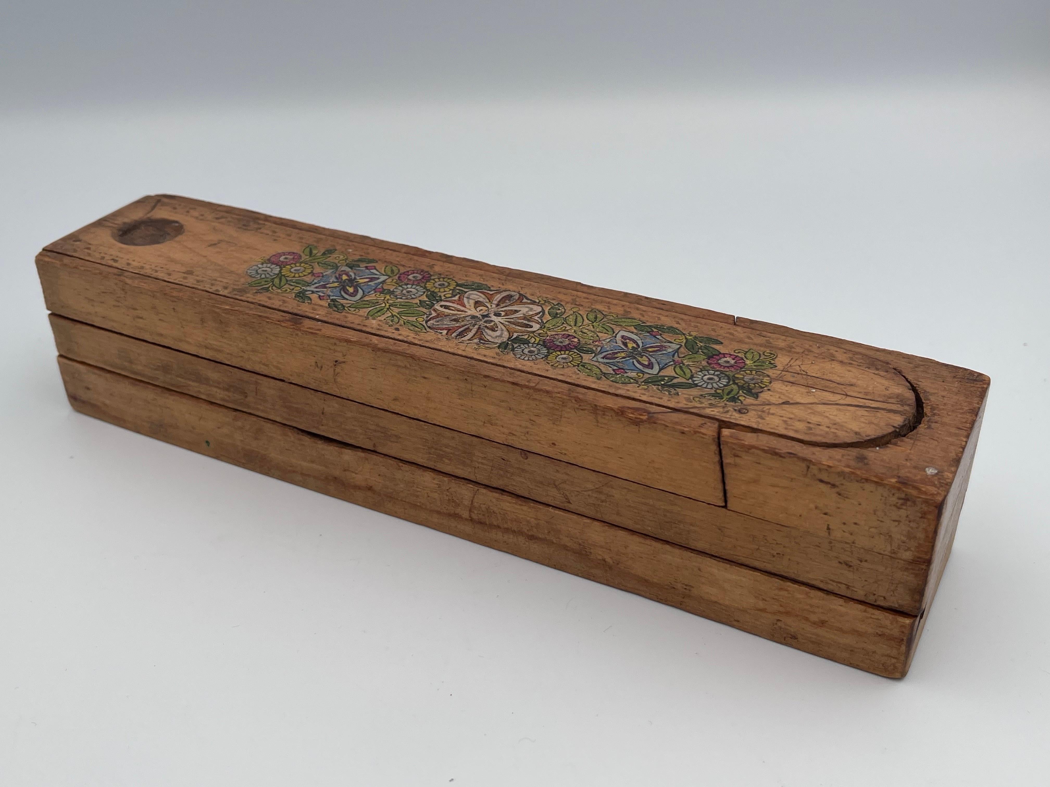This delightful early 20th-century decorated child’s pencil box is both functional and full of character. Crafted from hand-cut wood with a slightly rustic charm, the box bears a lithograph transfer floral decoration, reflecting the Arts and Crafts