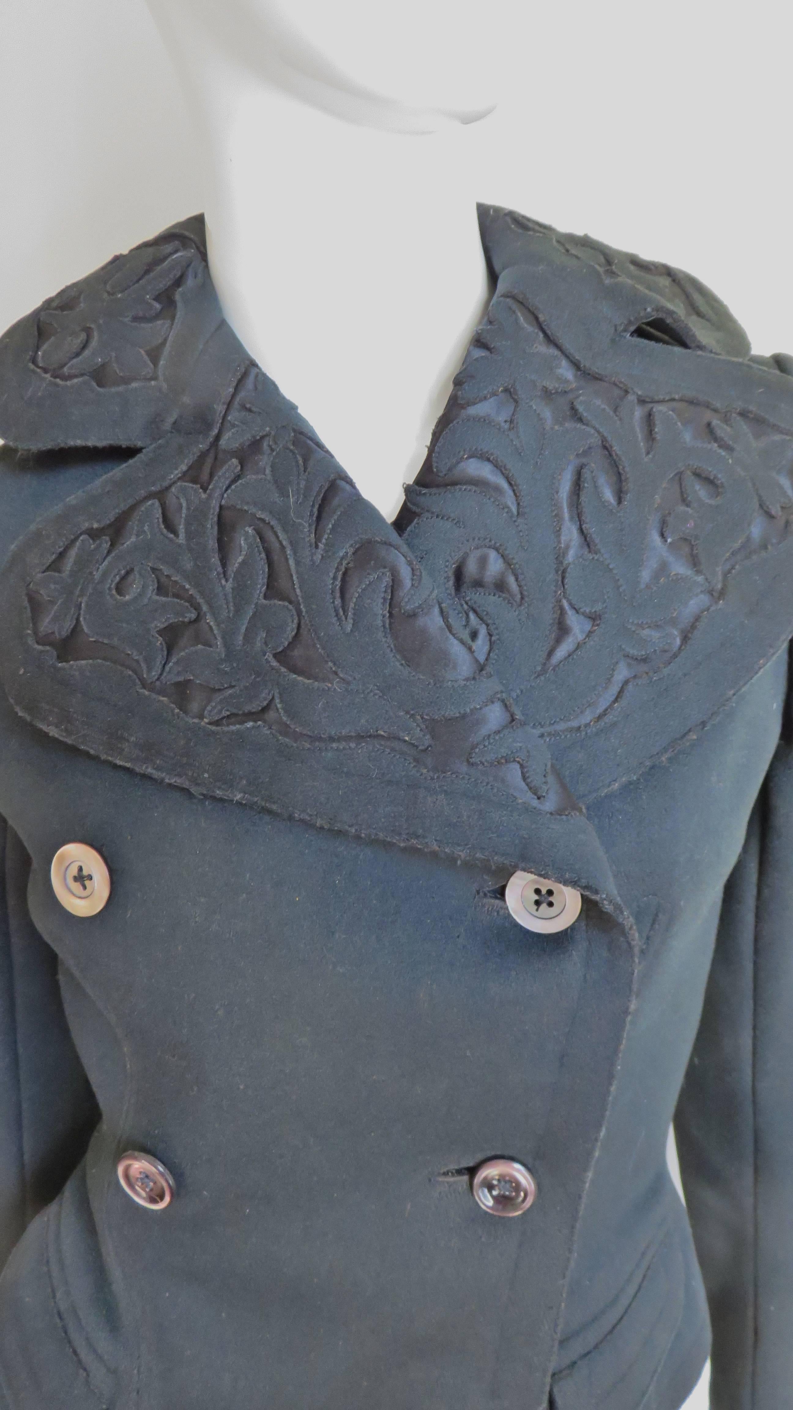 Eine unglaubliche reiche schwarze Wolle doppelreihige Jacke aus den frühen 1900er Jahren.  Es hat lange Ärmel, kleine Paspeltaschen in der Taille und einen abgerundeten Reverskragen mit aufwendig geschnittener, applizierter Wolle. Die Details sind