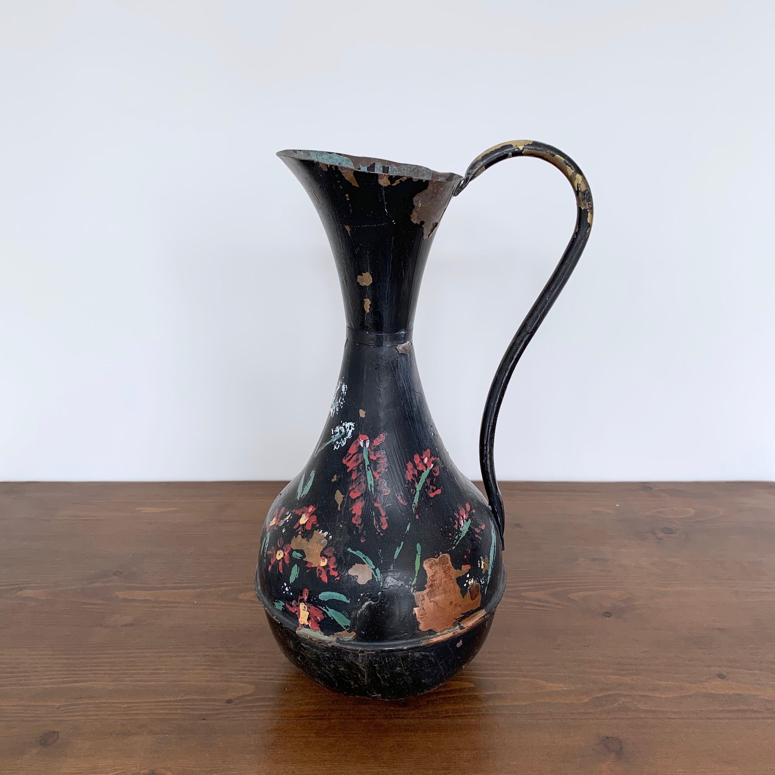 Early 1900s elegant French water jug. Made from copper with a brass handle it has previously been painted with black paint and floral motifs. The paint is worn in places and the copper has natural verdigris. Ideal as a decorative piece or to hold