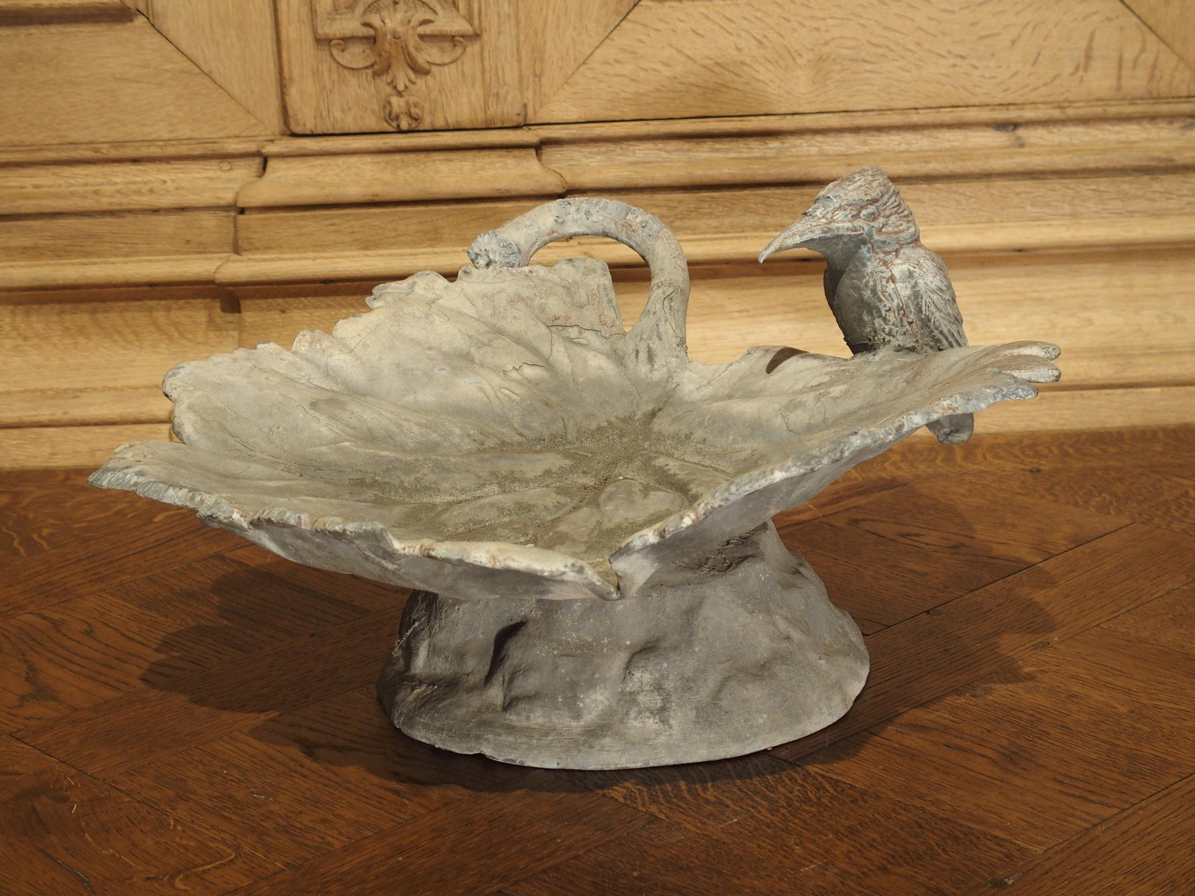 From England this lead birdbath dates to the early 1900’s. The bath depicts a kingfisher bird perched on the end of a large leaf (the leaf sits on top of a footed base). Kingfisher birds are typically brightly plumed birds with large heads and bills