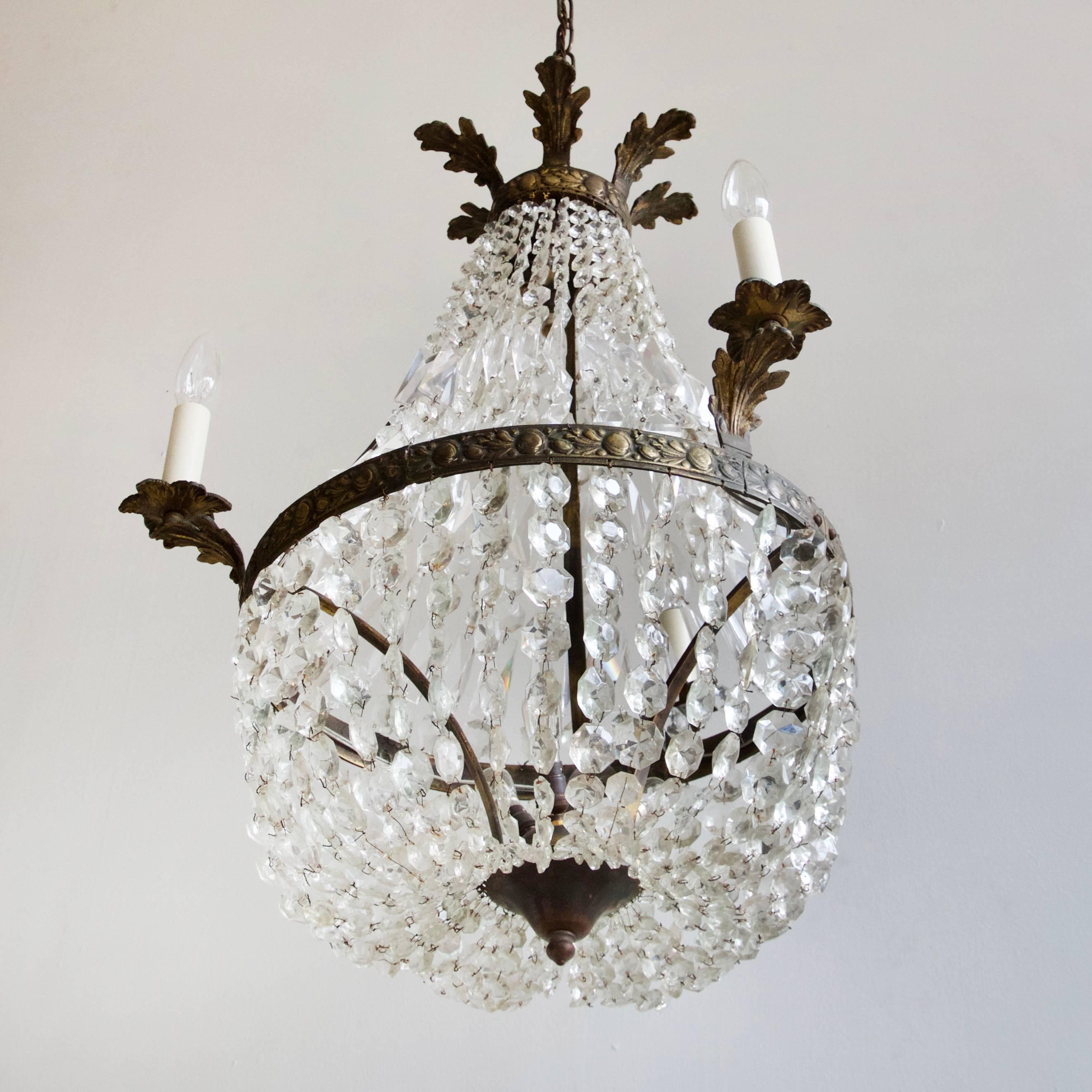 This balloon chandelier originates from early 1900s France. A tent of swags made from glass coffin lids and glass buttons forms the central body of the chandelier. Beneath the outer lamps more glass button swags drape to form the lower balloon. The