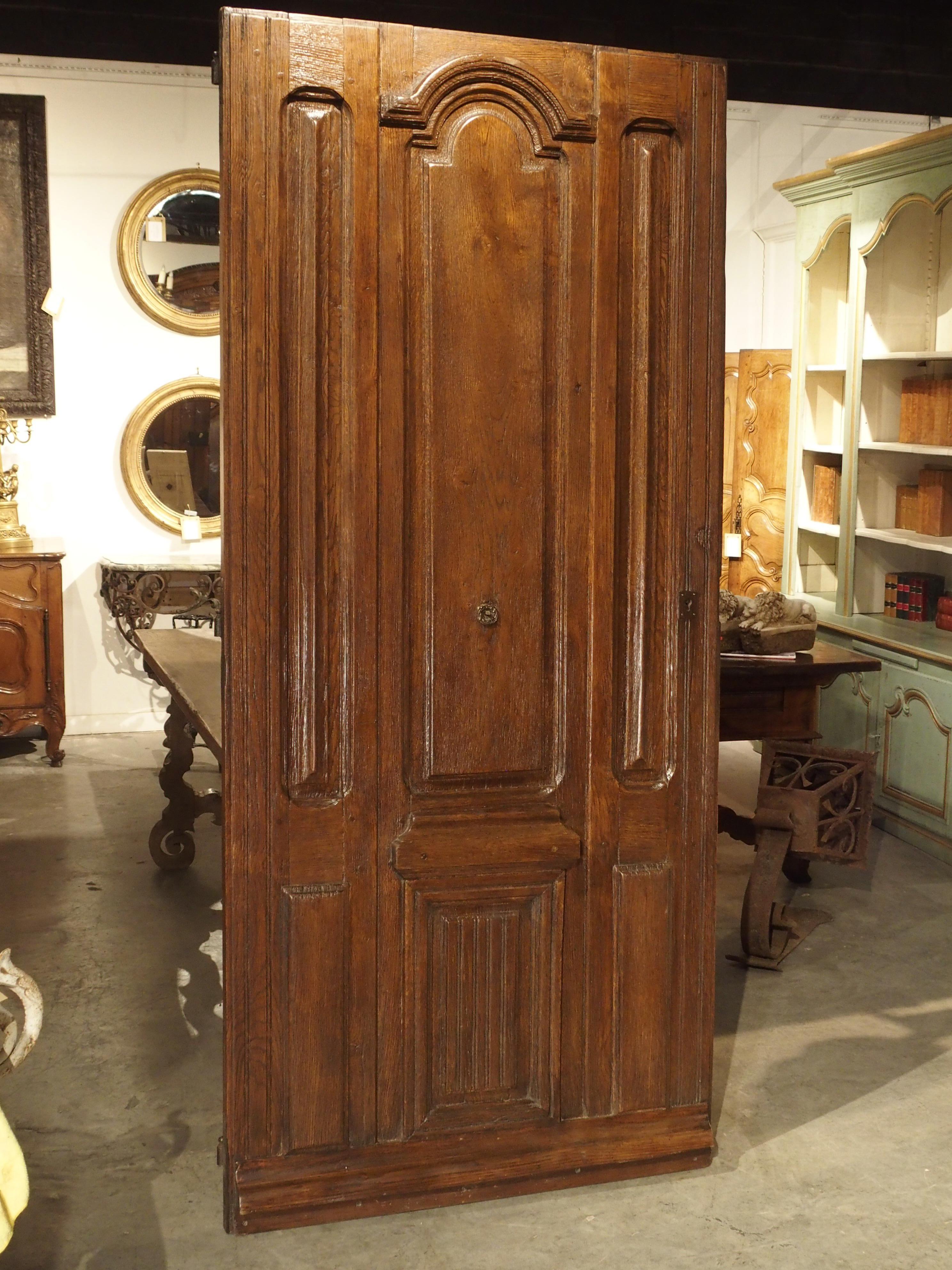 Louis XIV ornamentation was imbued with symmetry, balance and majesty. From France, this remarkable Louis XIV style entry door has elegant inset panels with stepped out moldings on its frontage. The tall vertical moldings visually add to the height