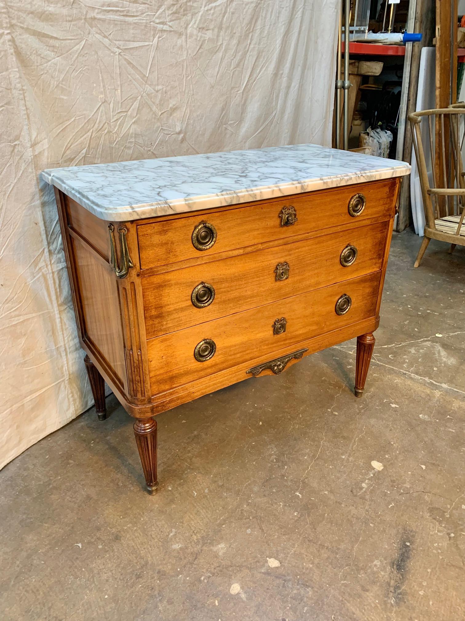 Found in the South of France, this early 20th Century French Louis XVI Style Chest of Drawers was crafted in France in the early 1900's from aged walnut and marble. The marble top is original to the piece and features rounded corner edges in the