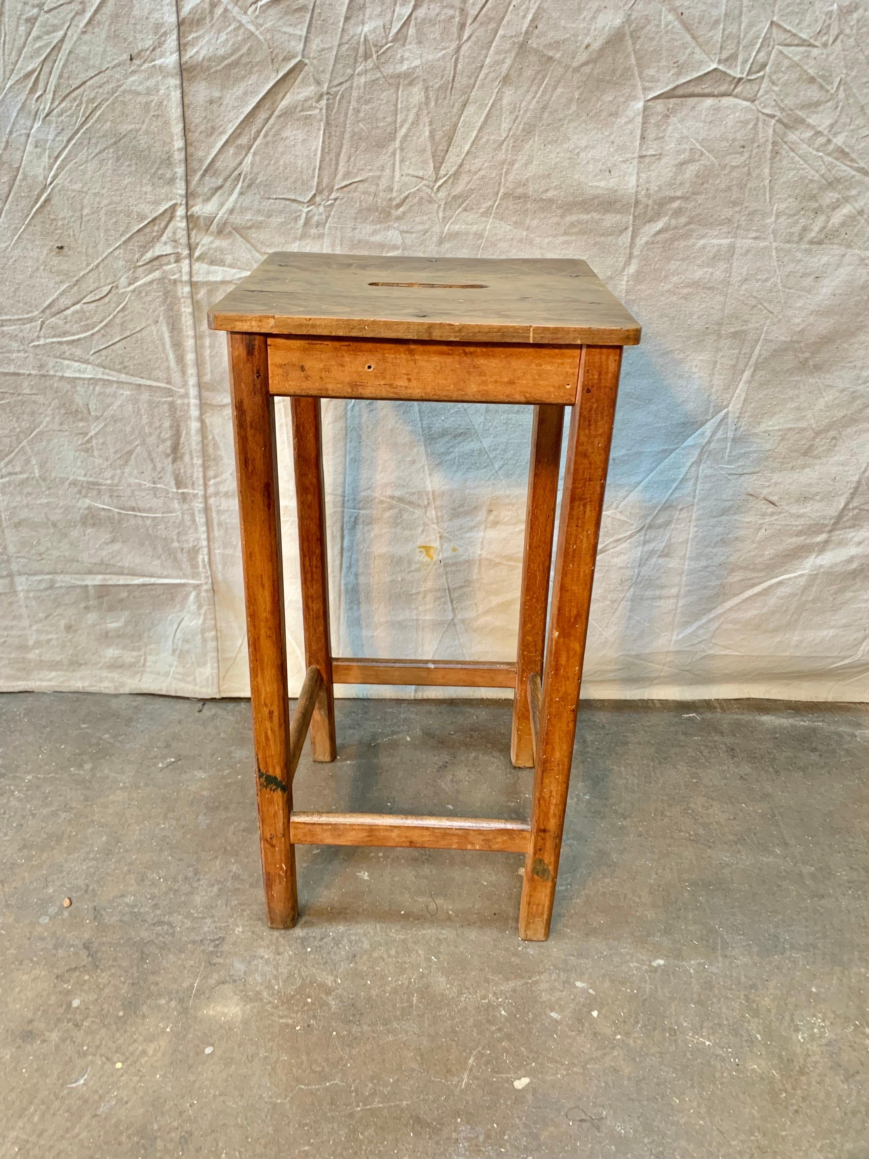 Found in France, this Early 1900s French Pine Train Station Stool features a finger hold in the top for easy transport.  The size of the piece lends it to be used as a stool or a side table beside a chair.  Well made and solid, great lines and