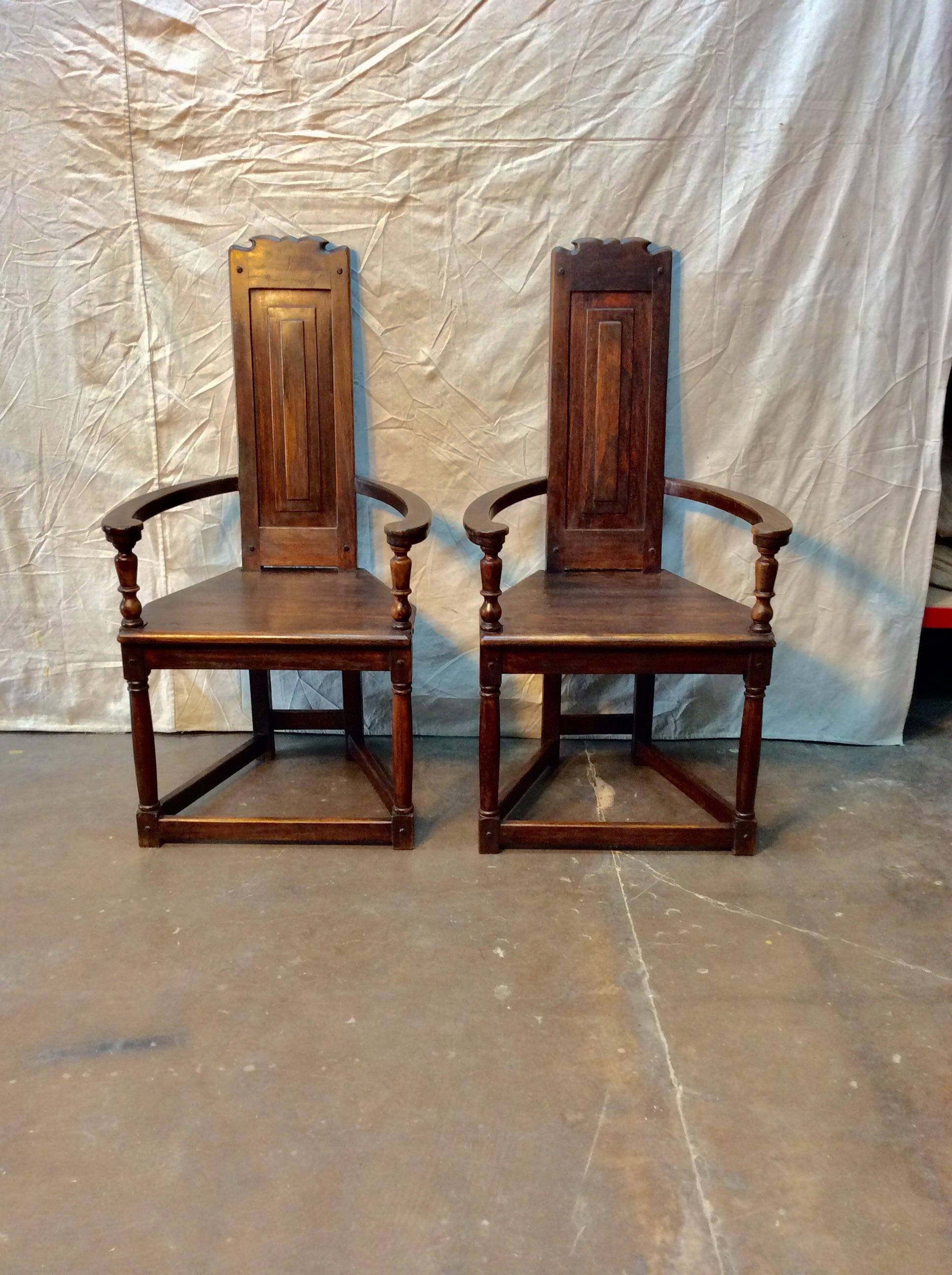 Found in the South of France, this pair of French Walnut Armchairs were crafted in the early 1900s. Each chair features barrel style arms with a carved narrow seat back. The solid wood trapezoidal shaped seat rest on turned legs flanked by
