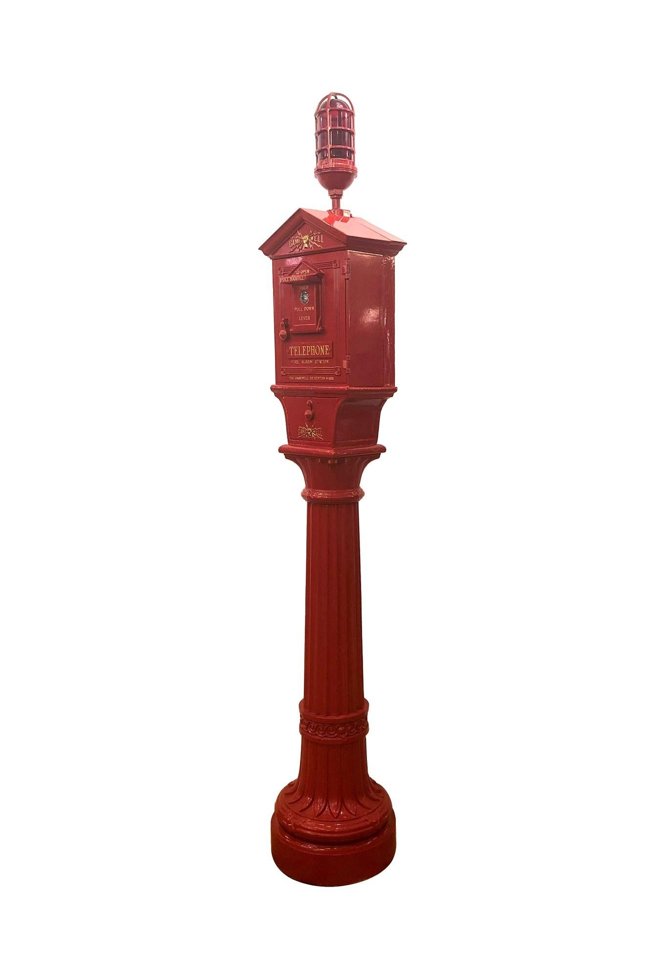 Fully restored antique fire alarm call box with telephone, alarm pull and flashing light. It is made of cast iron which is painted red with gold lettering and has an ornate pedestal base. Made by the Gamewell Company. This is fully restored and in