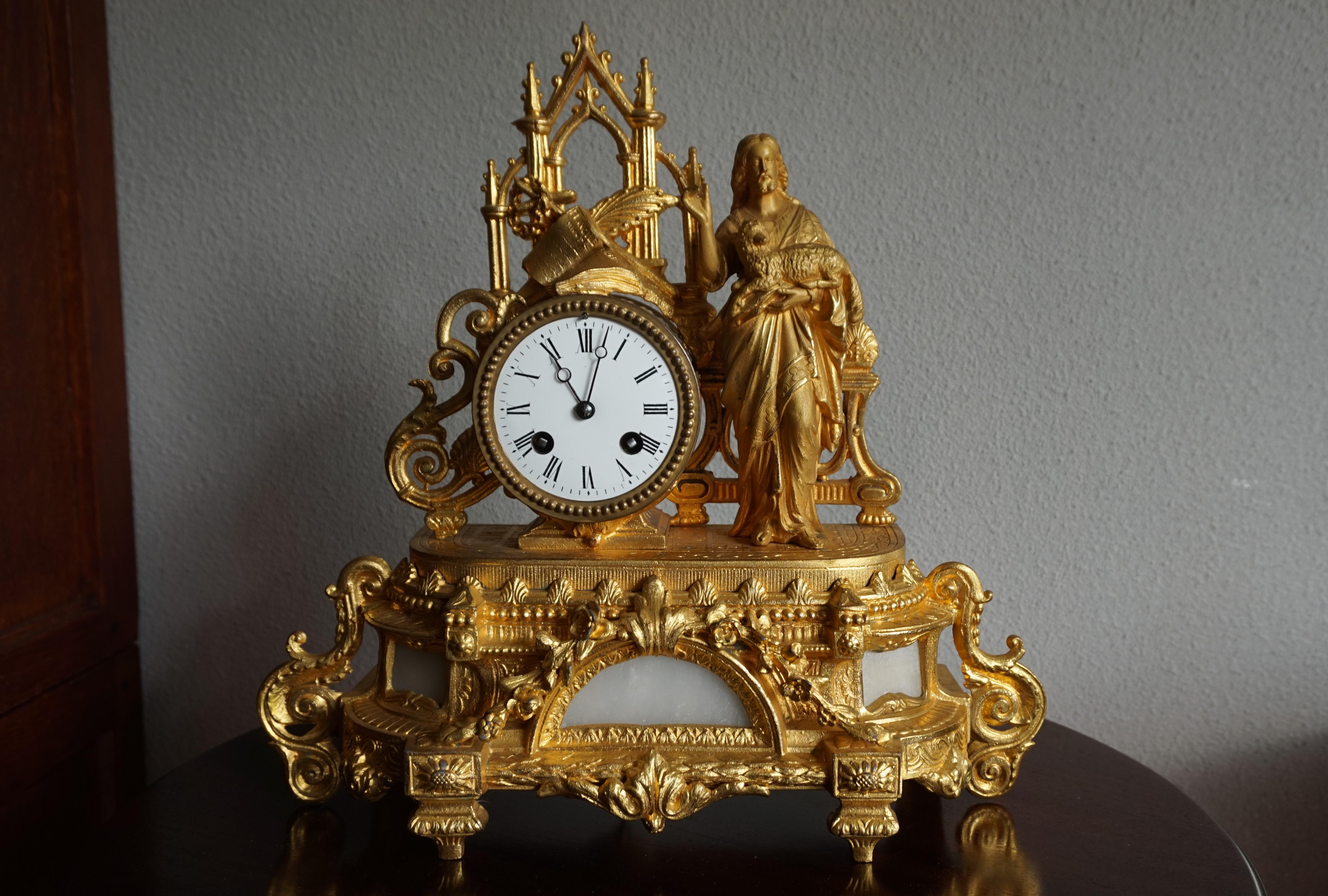 Stylish and meaningful Gothic mantel clock.

This elaborate clock and religious work of art into one dates back to the earliest years of the twentieth century. Standing on the richly decorated and alabaster inlaid base is Jesus holding a lamb. This
