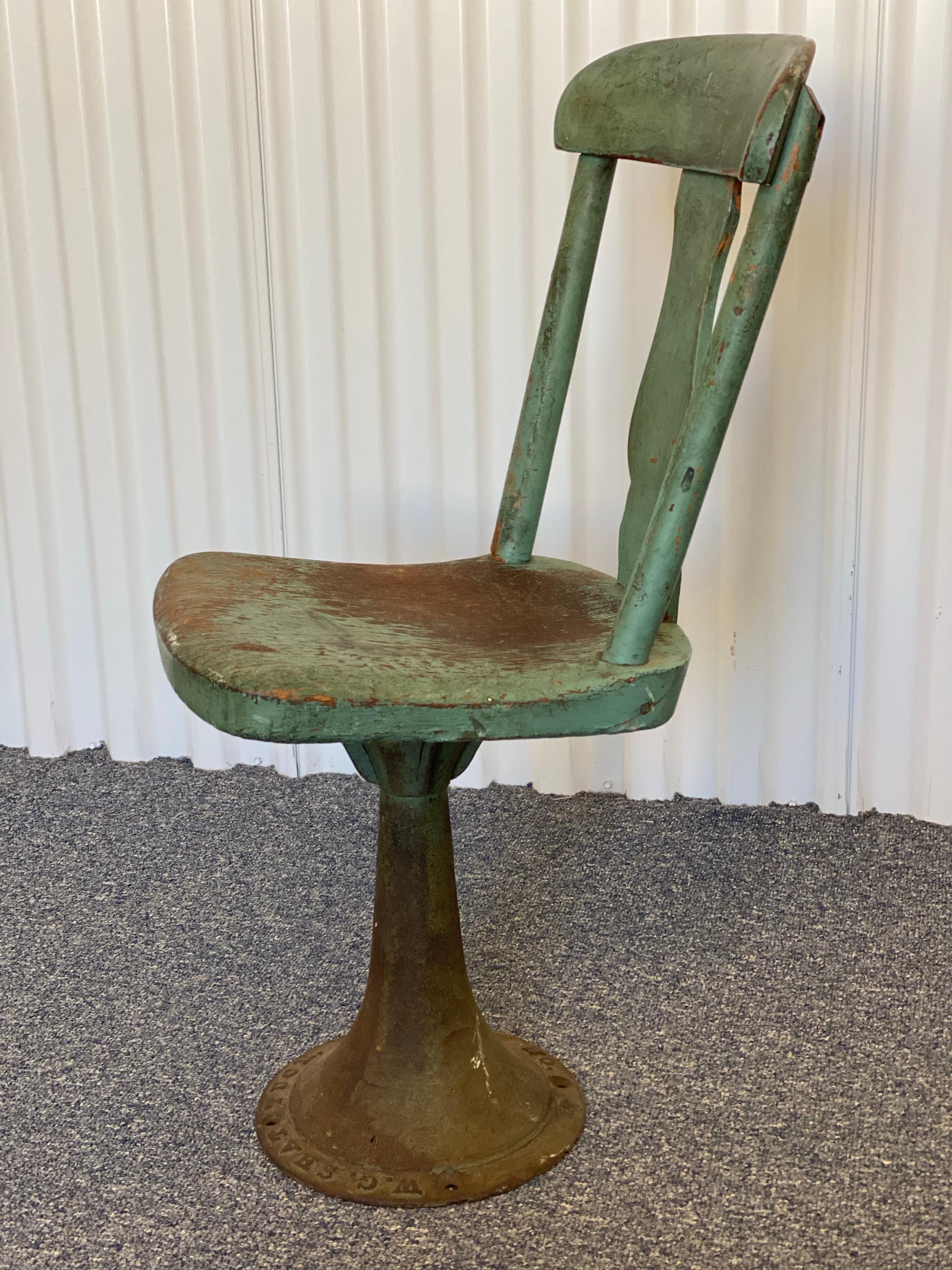 Chaise d'enfant en bois et métal peint en vert, datant du début des années 1900.
Cette chaise pivotante antique est construite en bois et en fonte.  La chaise présente un dossier simple, légèrement incurvé, et une assise plate. La base est un