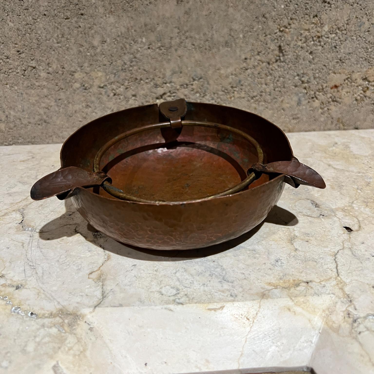 AMBIANIC presents
Early 1900s Hammered Copper Ashtray with 3 cigarette slots
Arts and Crafts period USA
2 h x 6.5 diameter
Unmarked
Original vintage unrestored
Refer to images