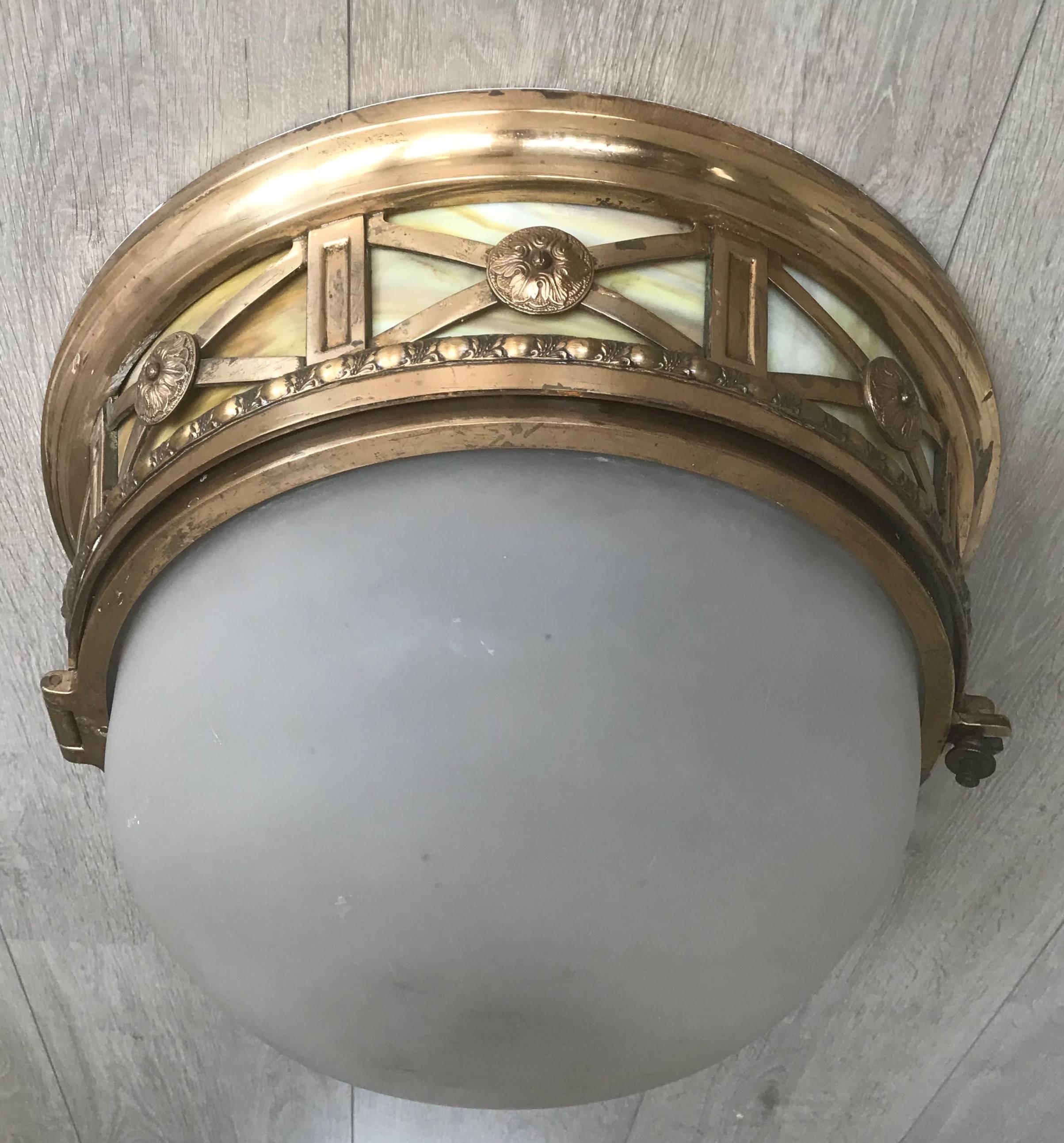 Rare Art Nouveau era three-light flush mount.

This out of the ordinary, French antique flush mount is beautiful in shape and decorated with fine bronze ornaments and two types of glass. This upside down dome shape flush mount of rich materials has