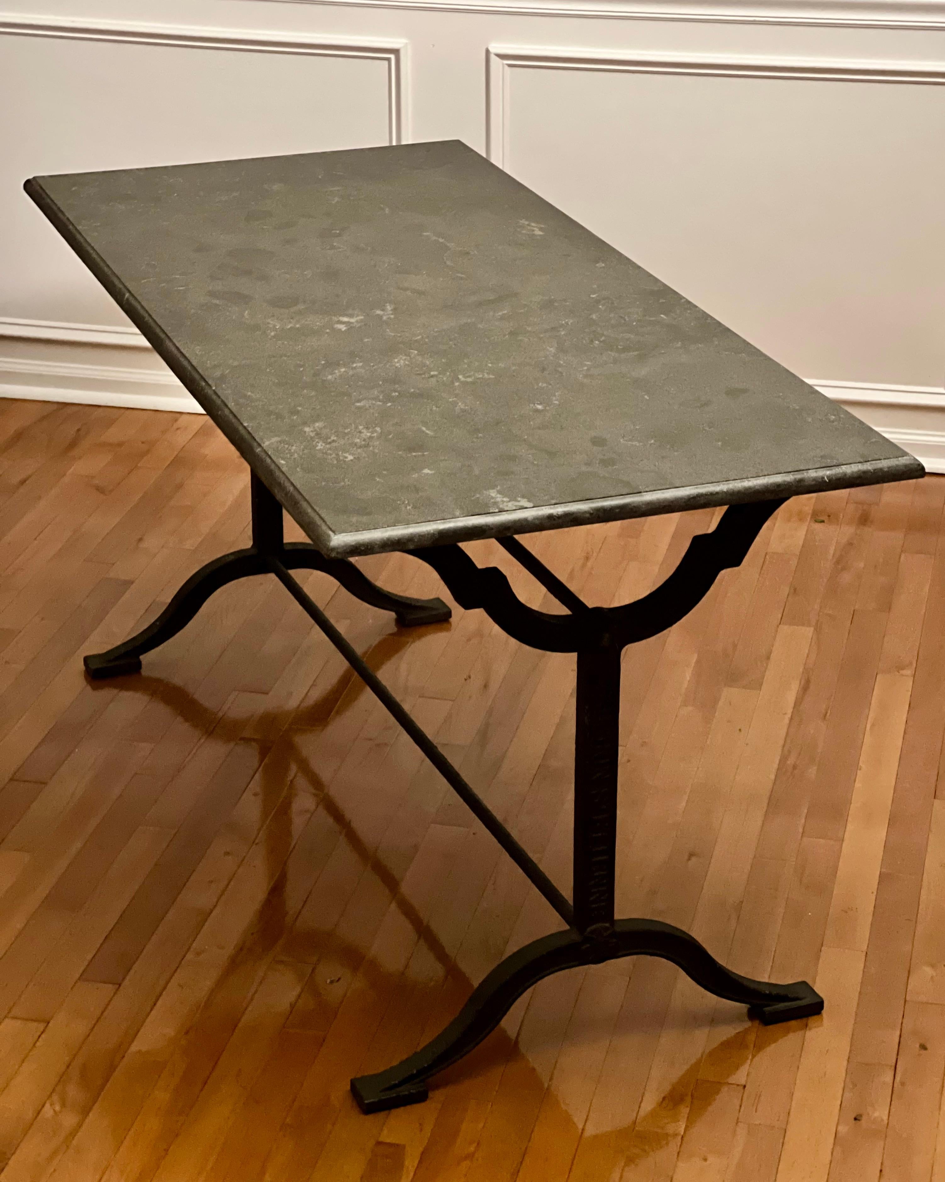 Classic style long French bistro or garden table with iron base and dark gray stone top by L. Buchon, France, c. 1900.

This is a fantastic table with beauty and great versatility. An excellent size for dining but may also be used as a desk,