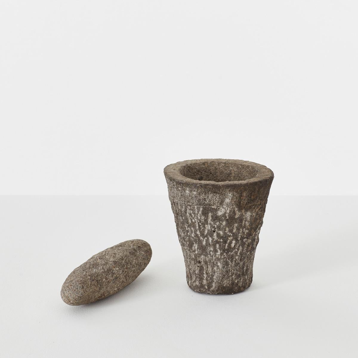 This cute mortar and pestle set has been naively carved from a lovely dark Granite stone.

The exterior of the mortar shows pleasing chisel marks across is surfaces whilst the internal bowl element is more smooth. It comes with a matching pestle