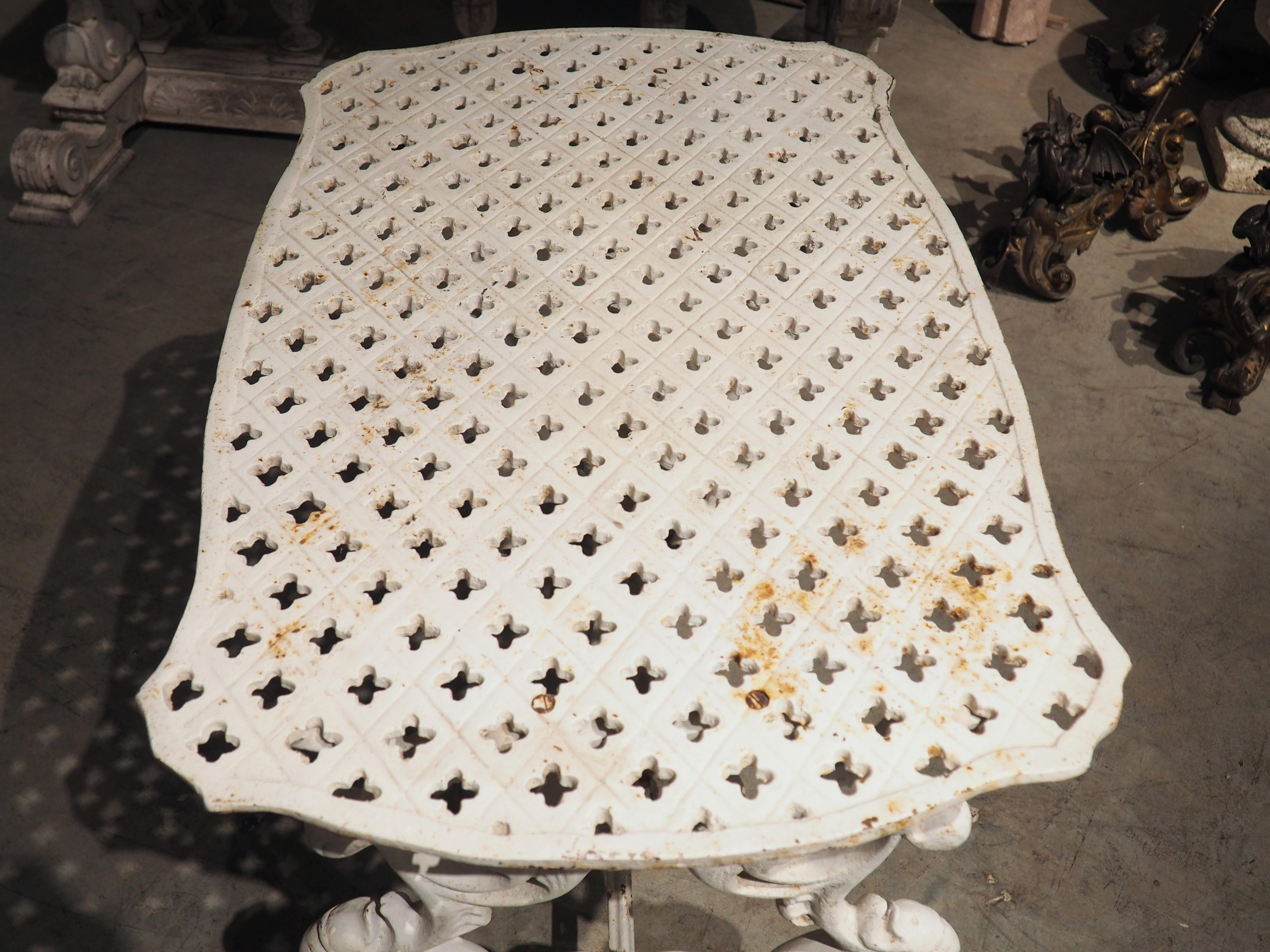 An interesting, early 1900’s side table from France, this cast iron table features a latticework shaped top over an elaborate foliate and baluster base. The roughly rectangular top has thin, undulating edges, surrounding a lozenge pattern filled